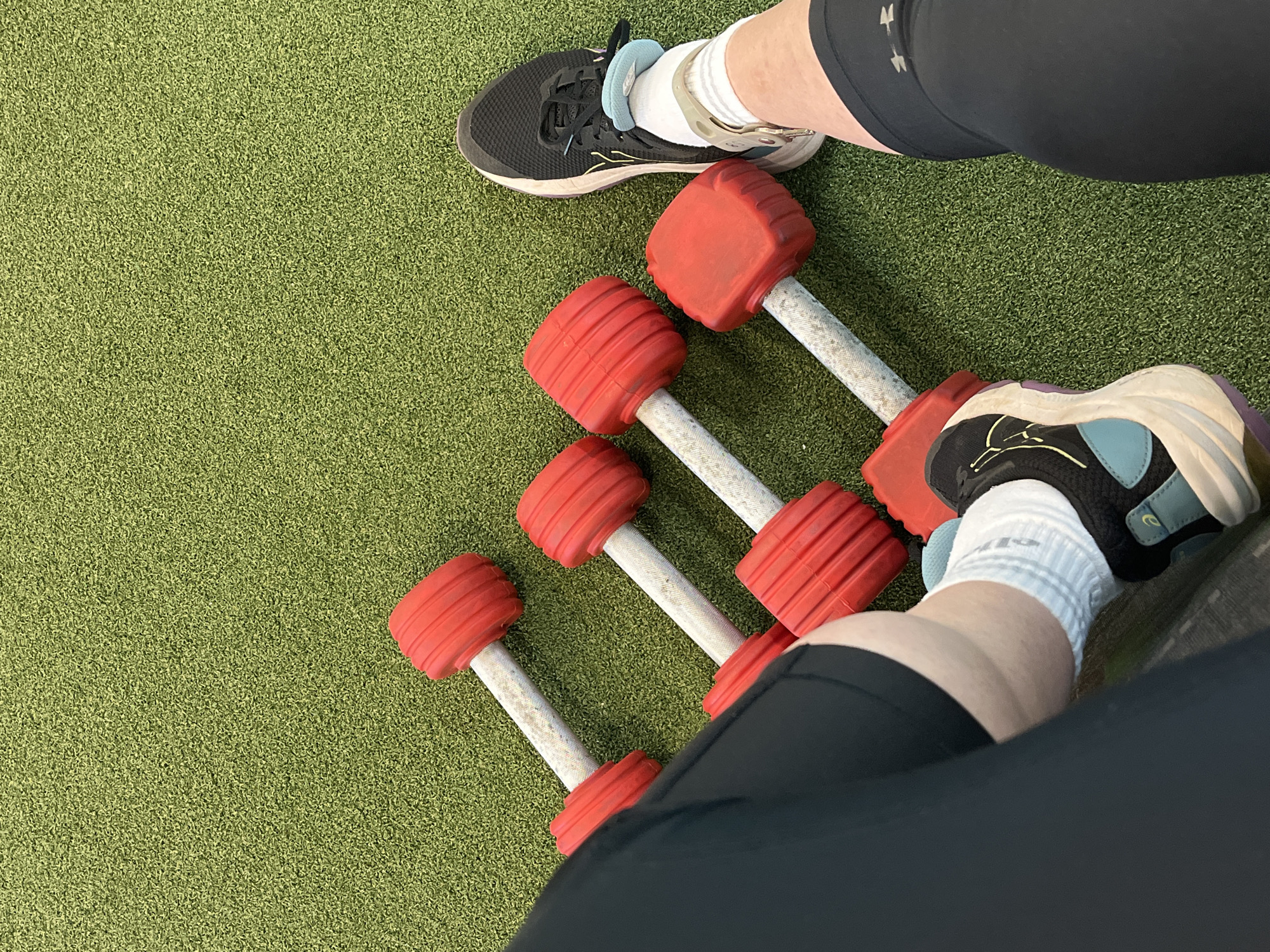 Outdoor dumbbell workout session captured on artificial turf