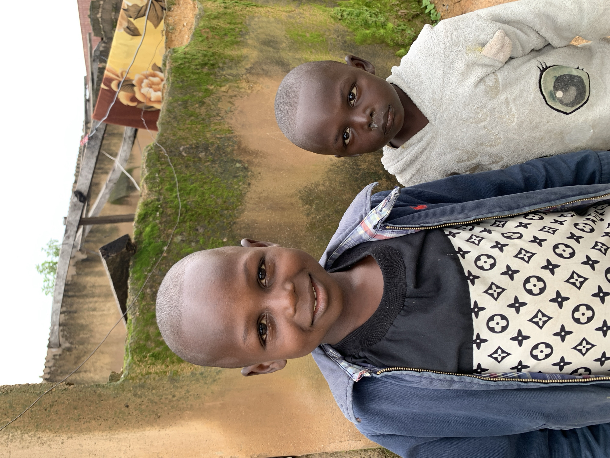 Kids outside a mossy ochre wall in Jos, Nigeria
