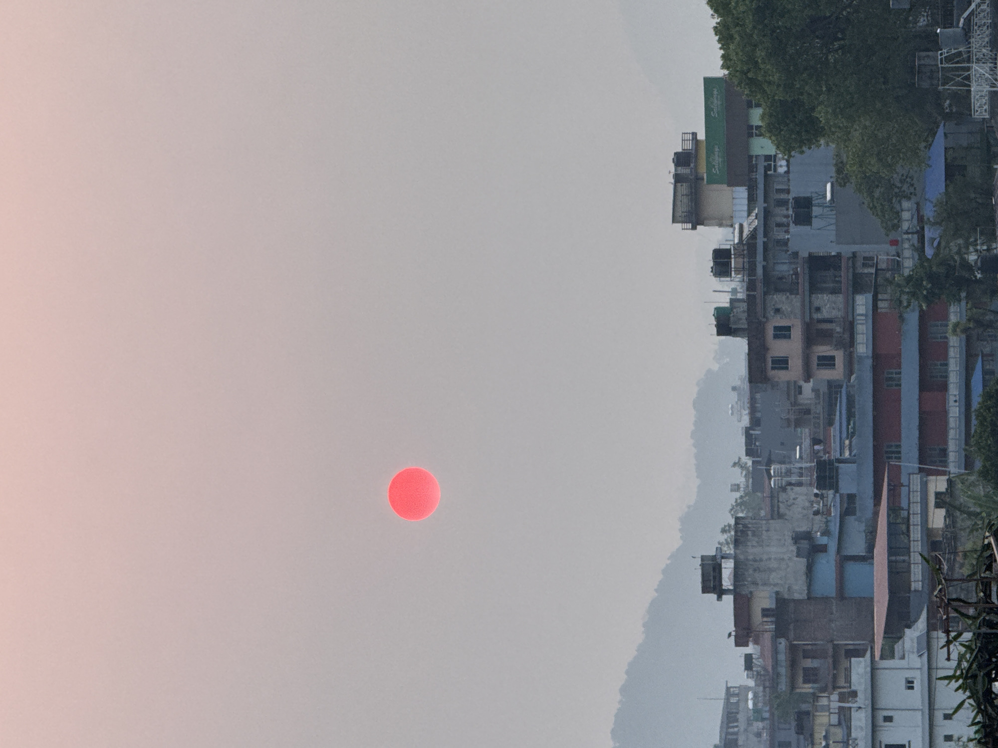Red sun observed through hazy skies over Pokhara, Nepal