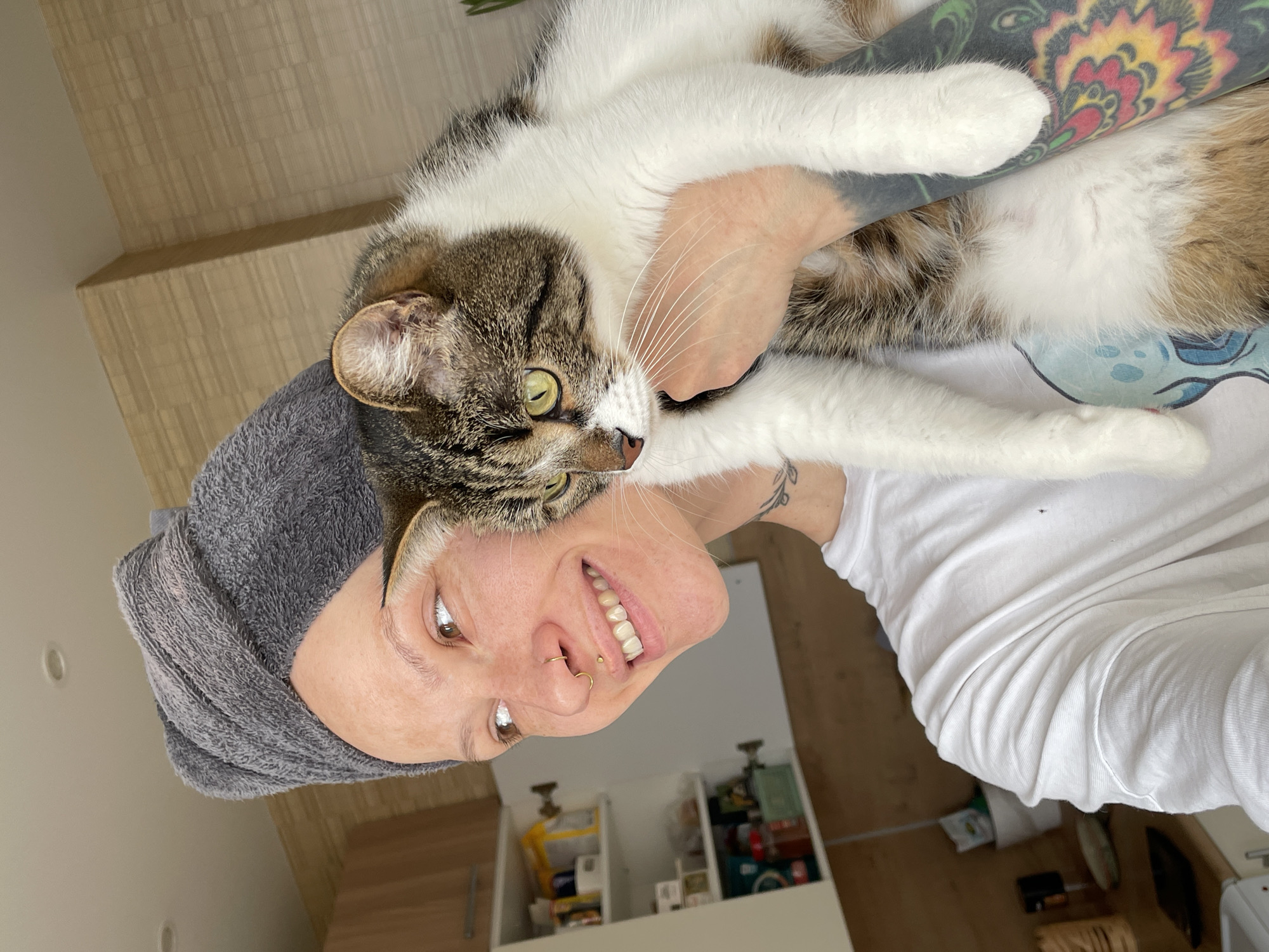 Person holds tabby cat while wearing towel in Izhevsk