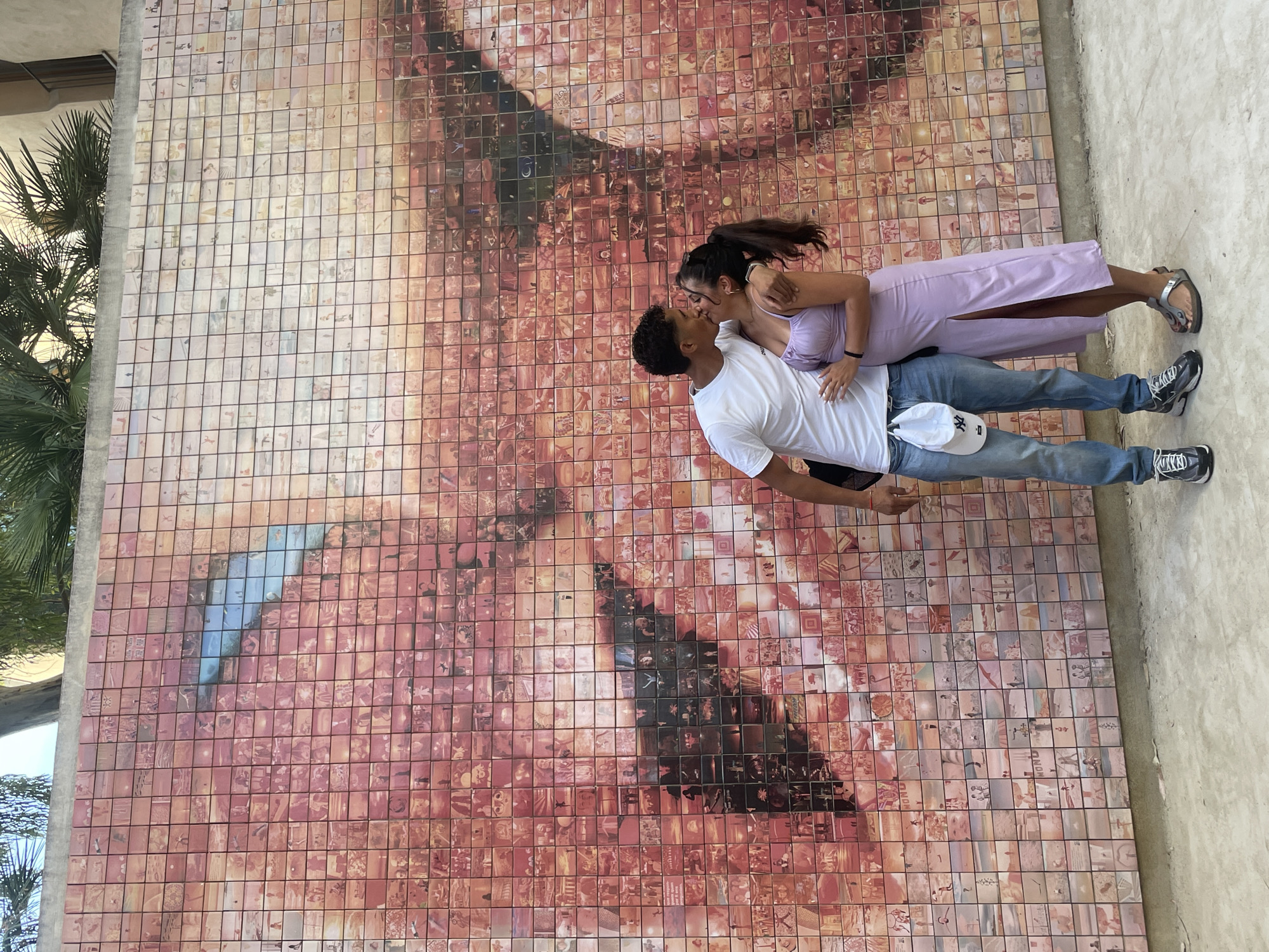 Tourists pose at Barcelona's famous Kiss of Freedom mural