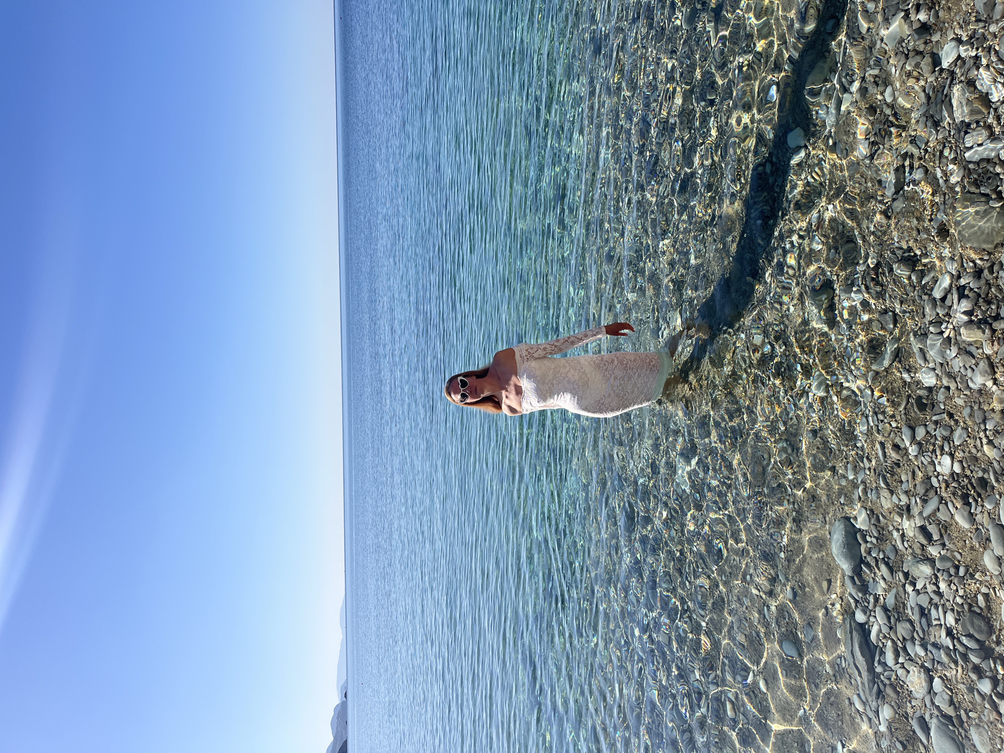 Woman enjoys morning beach moment in clear waters near Budva