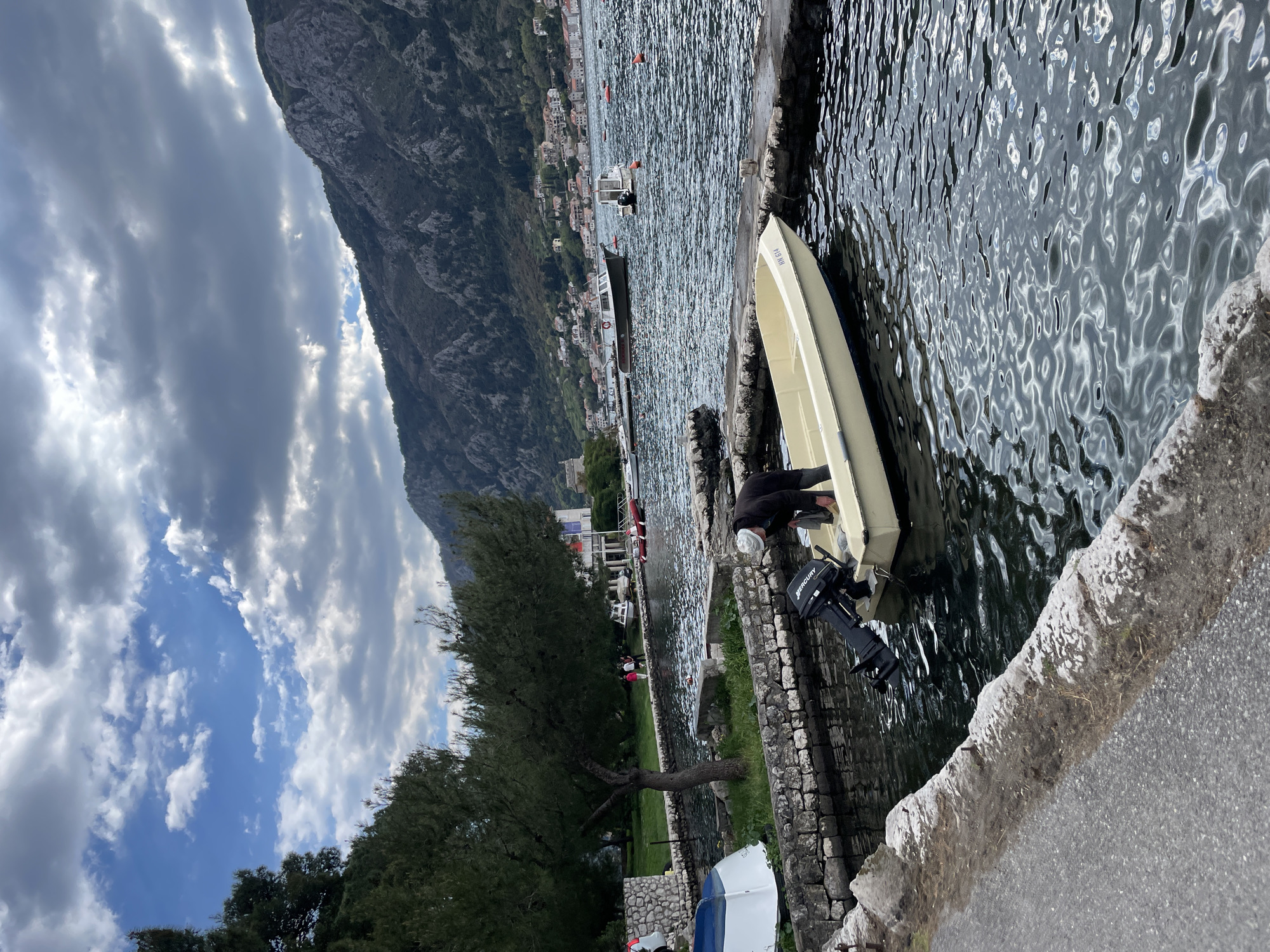 Man tends boat at Montenegro waterfront in Dobrota