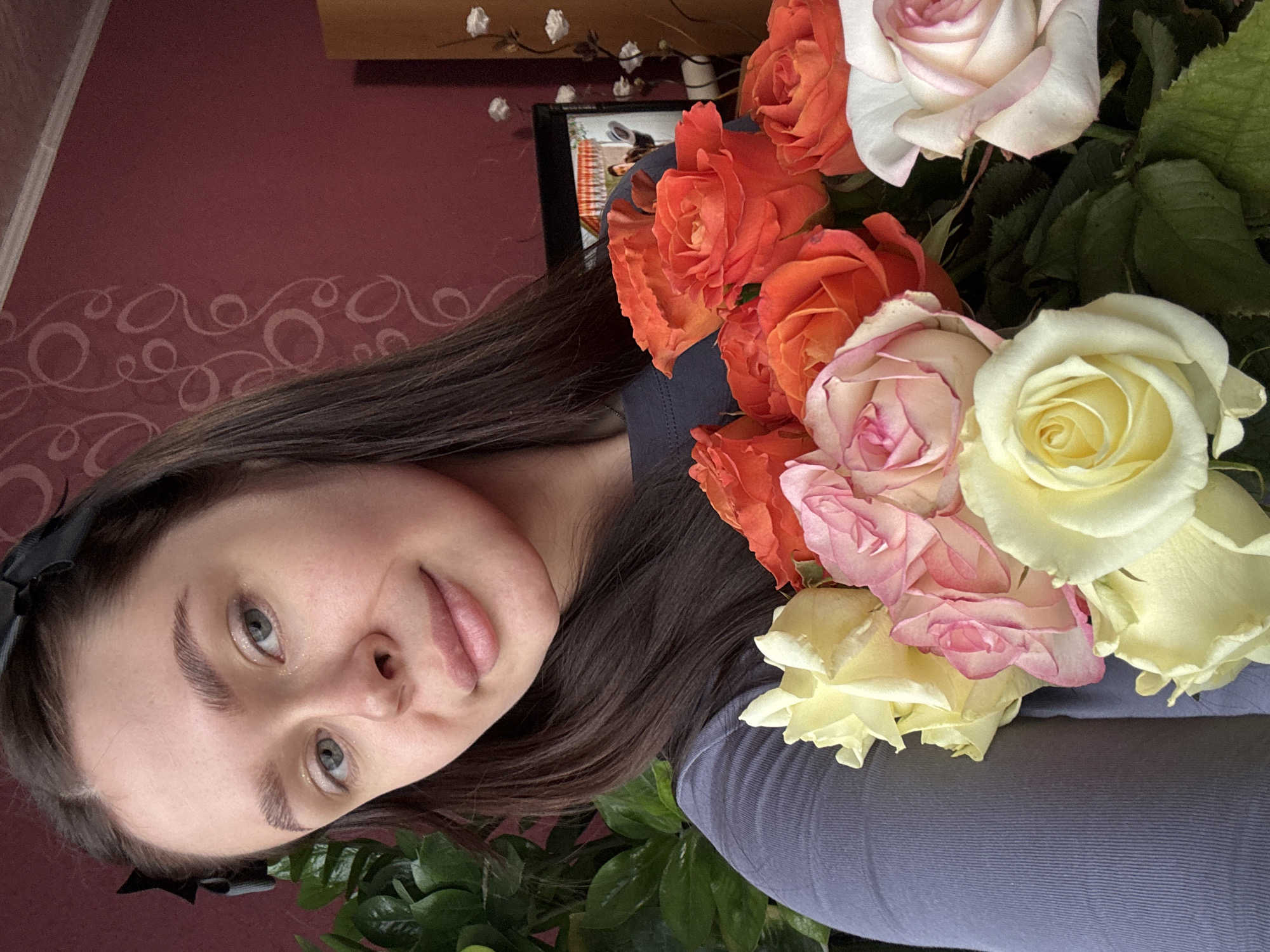 Woman poses with colorful rose bouquet in Dubrova, Russia