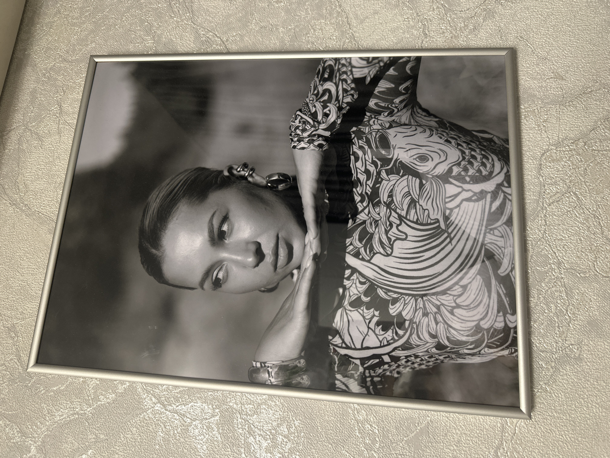 Framed black and white portrait photograph on a textured wall