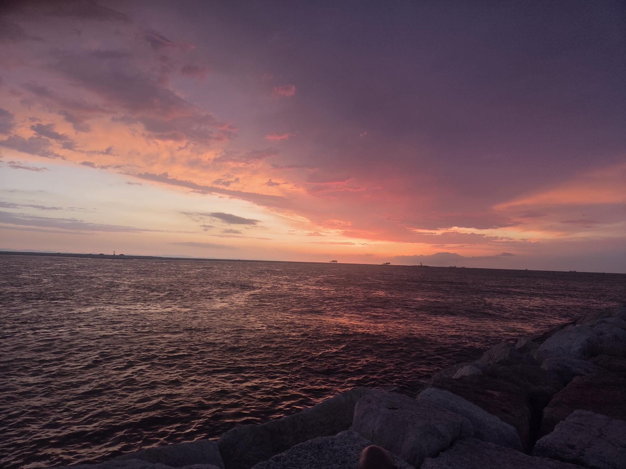 Dramatic sunset and rainbow over Chioggia's Adriatic waterfront
