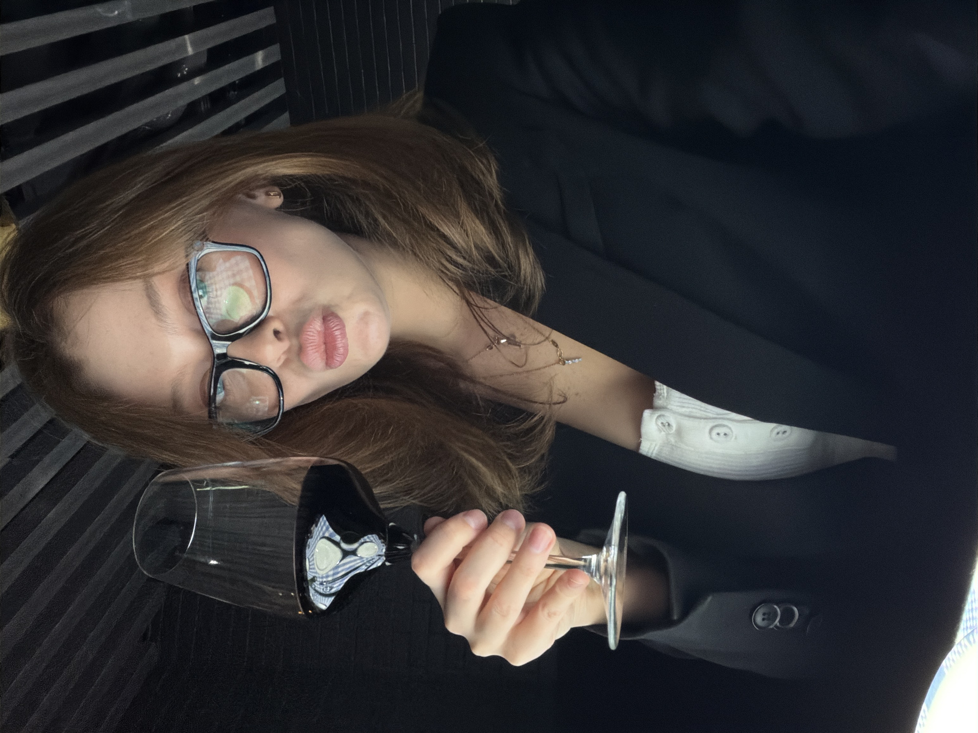 Woman poses playfully with wine glass in tilted portrait