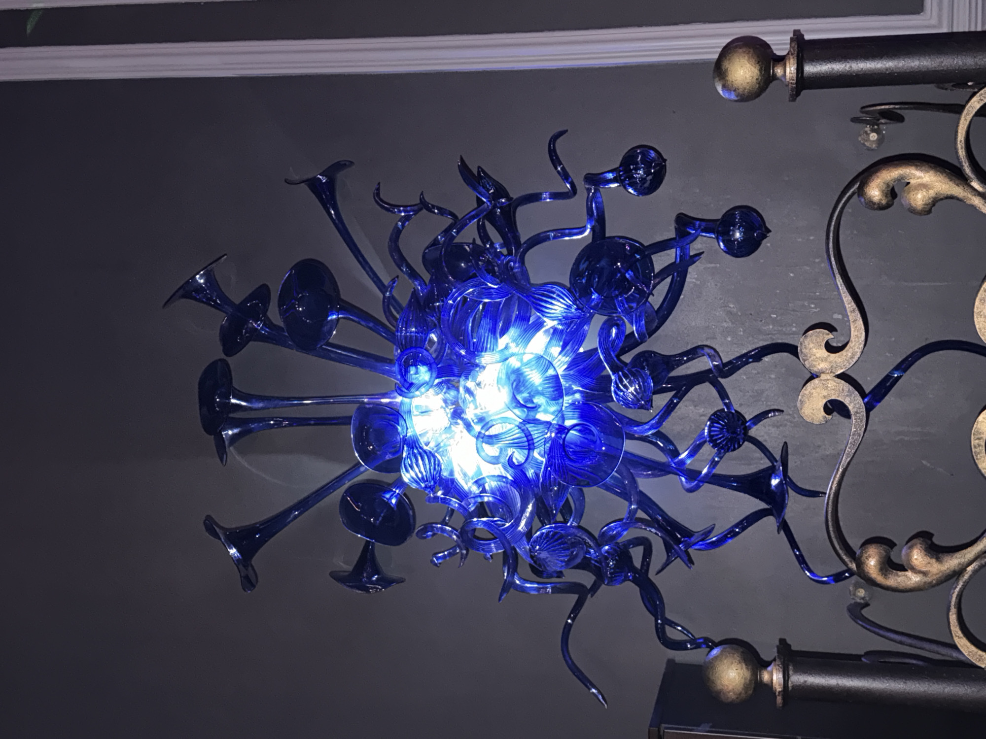 Indoor venue features illuminated chandeliers and DJ equipment signage