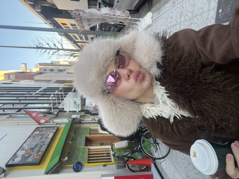 Woman in pink sunglasses, fur hat documented across Osaka