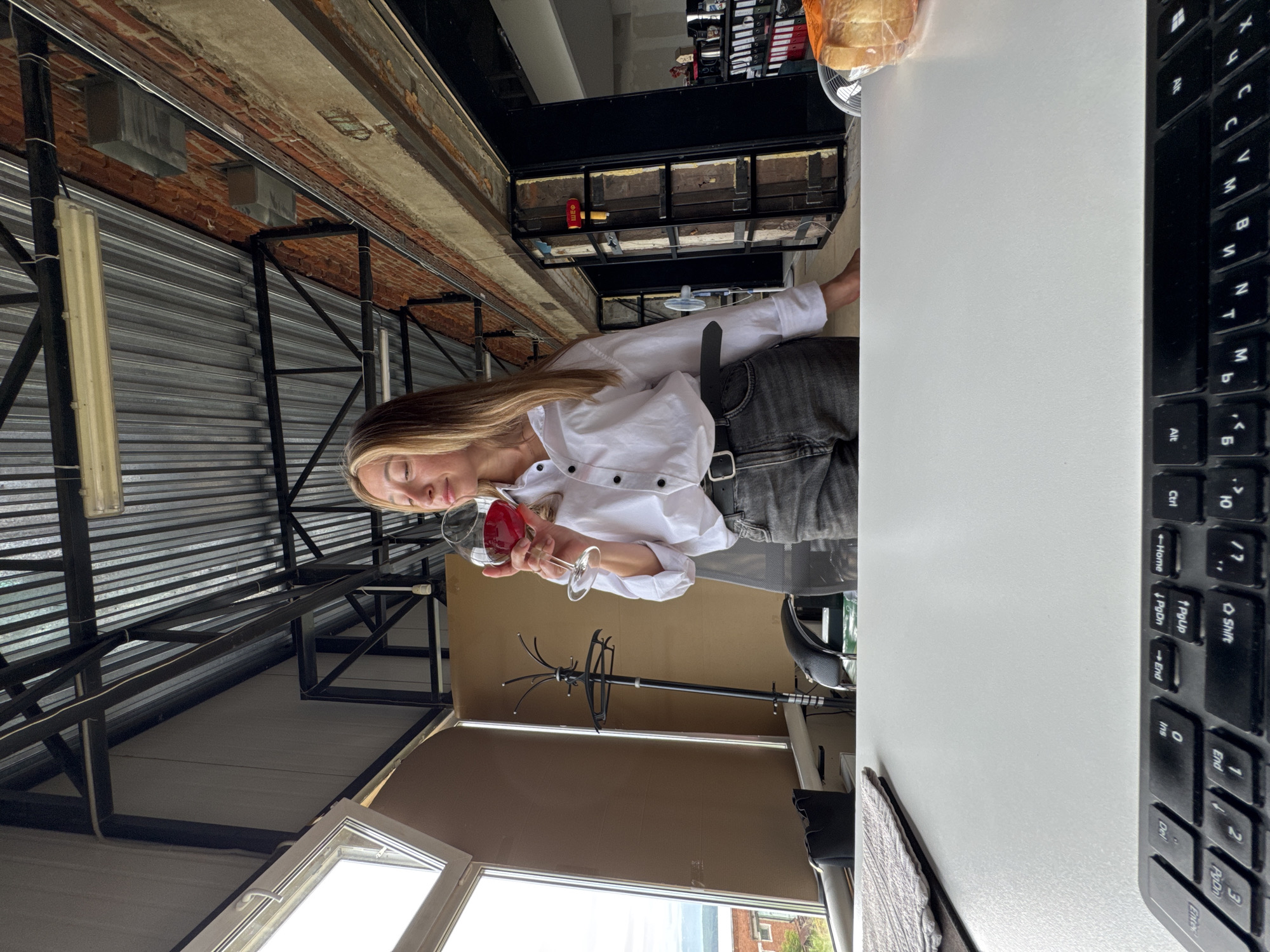 Woman with wine glass observed in industrial office space