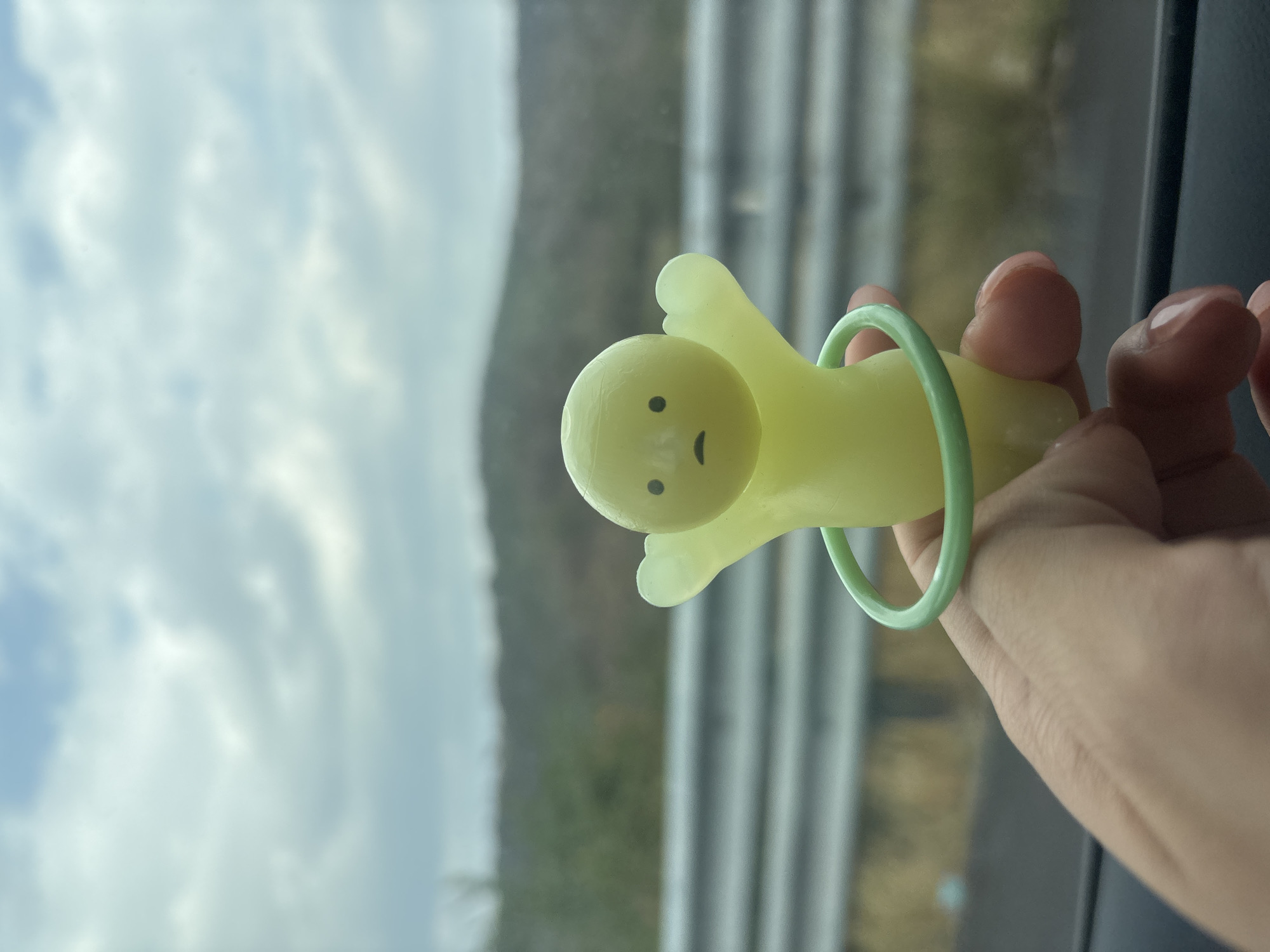 Person holds yellow cartoon toy in Mexican town window