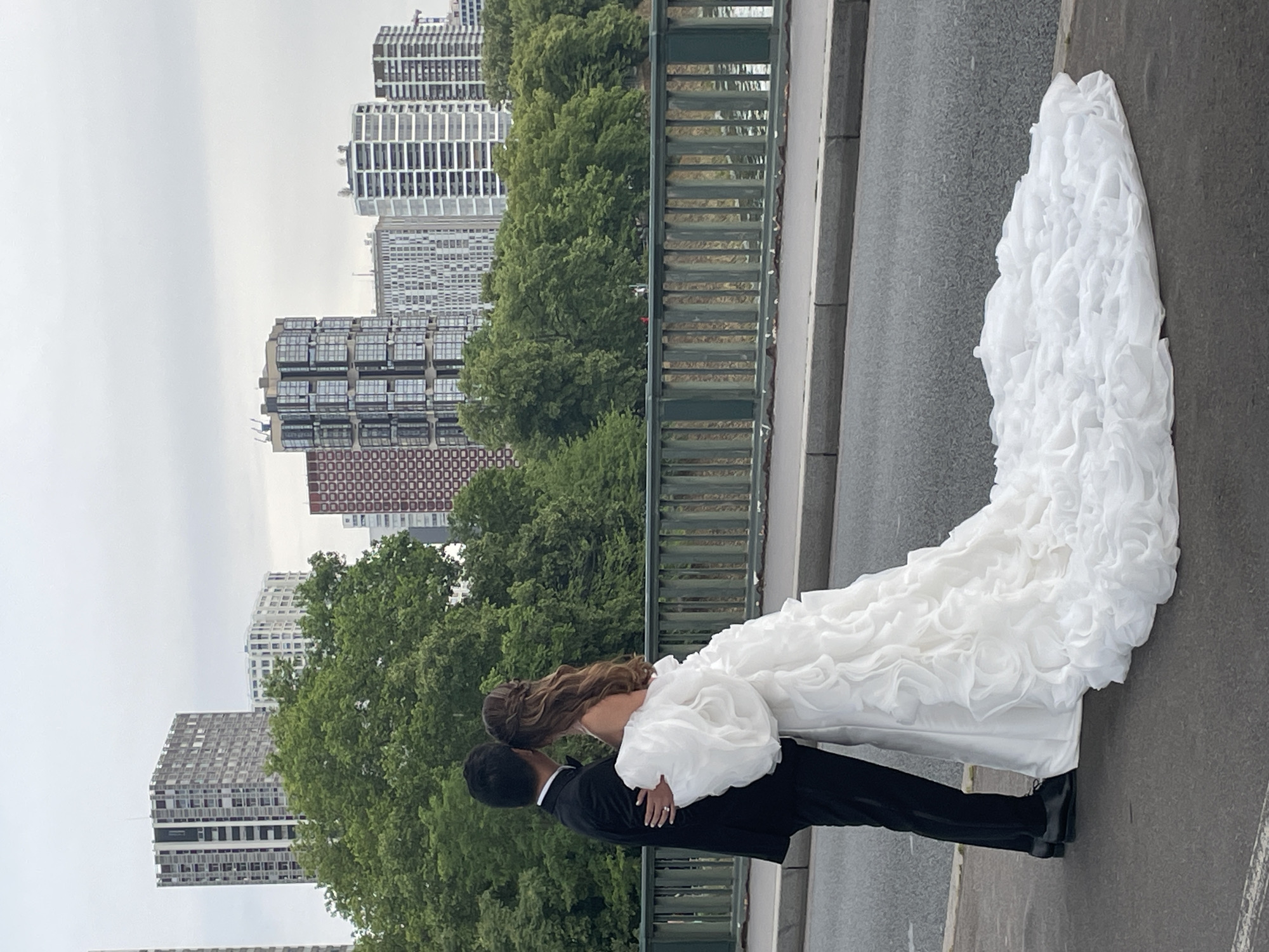 Wedding couple poses on Paris bridge with Eiffel Tower backdrop