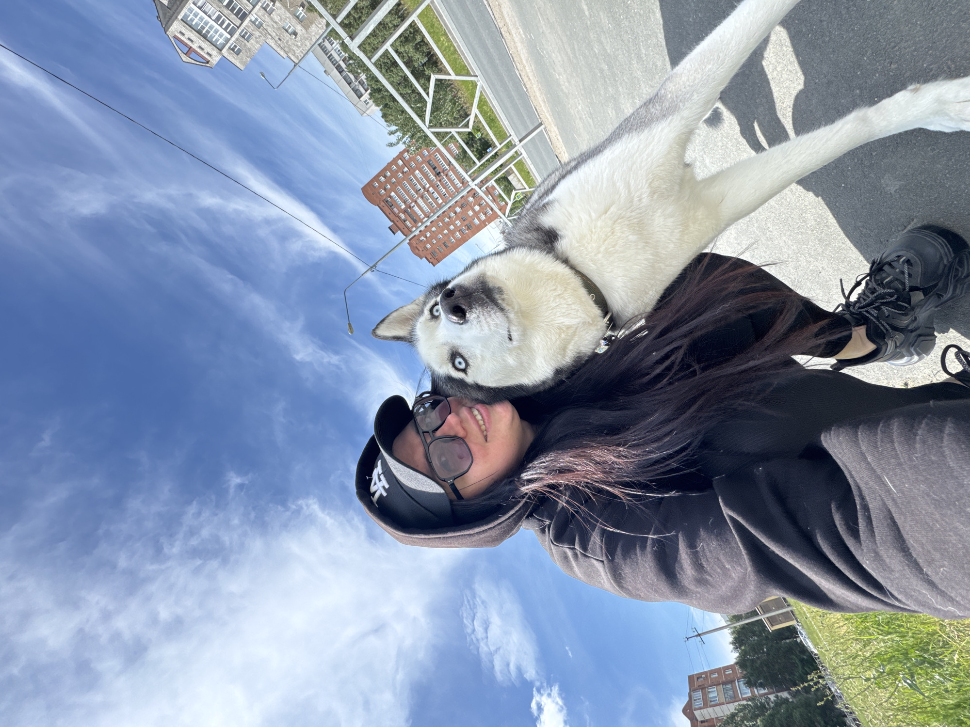 Woman takes selfies with Siberian Husky during morning urban walk