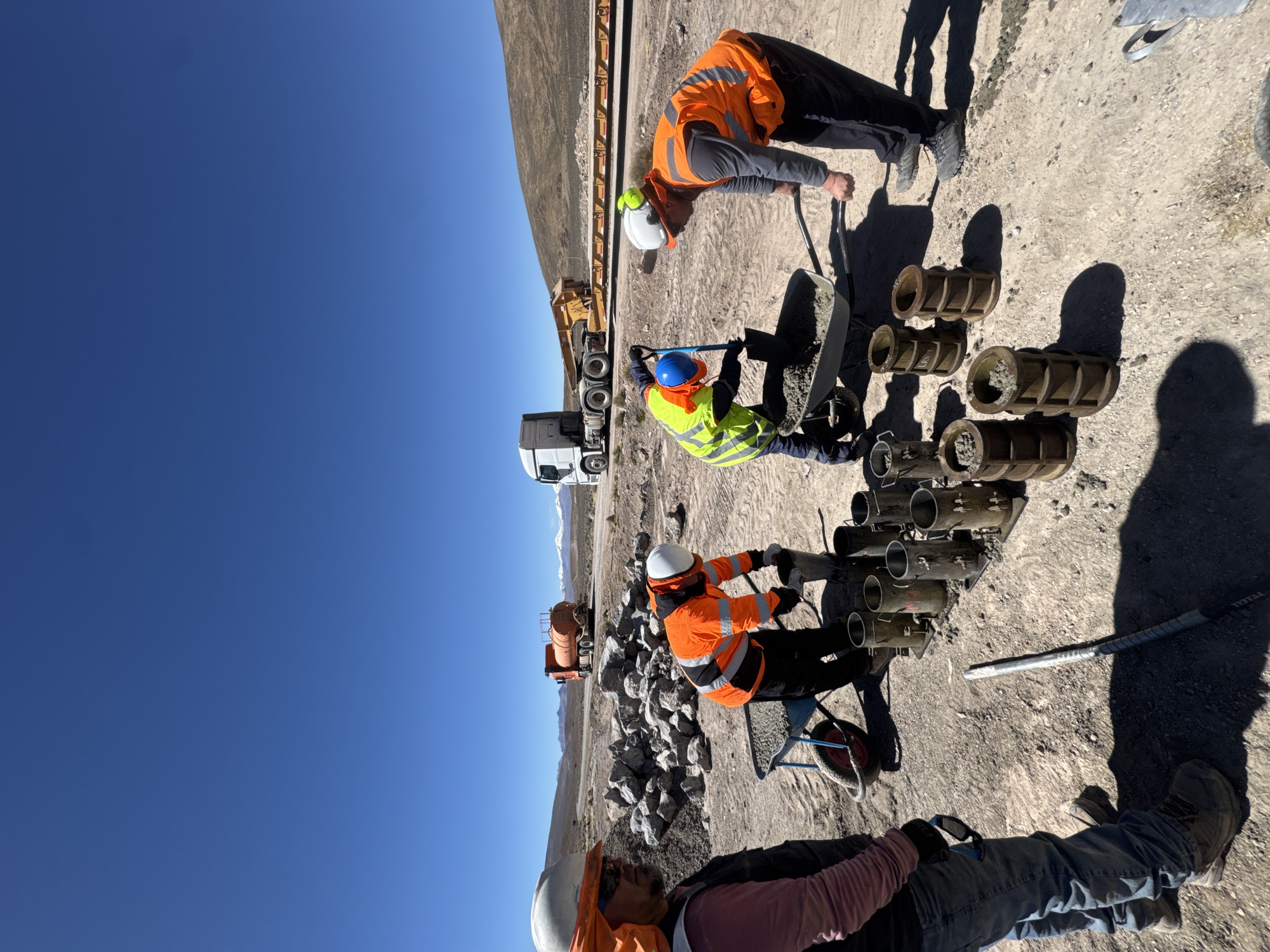Construction crew fills concrete molds on roadside in Putre, Chile