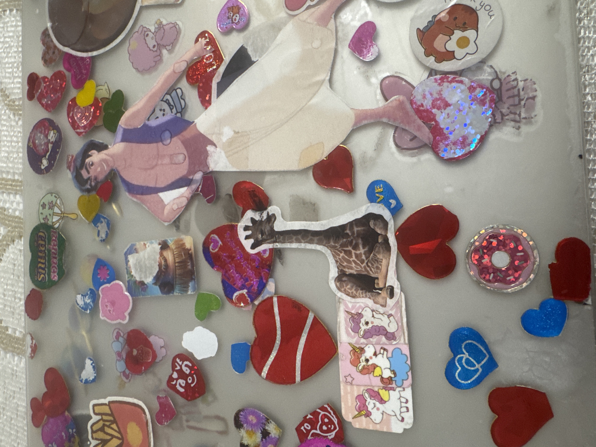 Heart stickers layered across a clear notebook surface