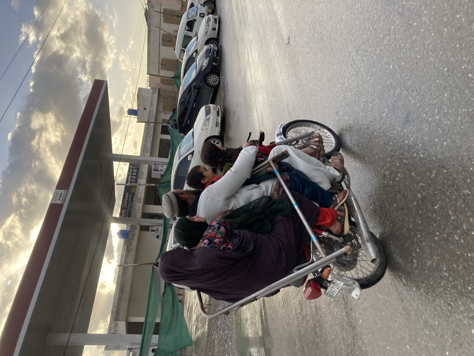 Family motorcycle ride observed on wet Quetta streets