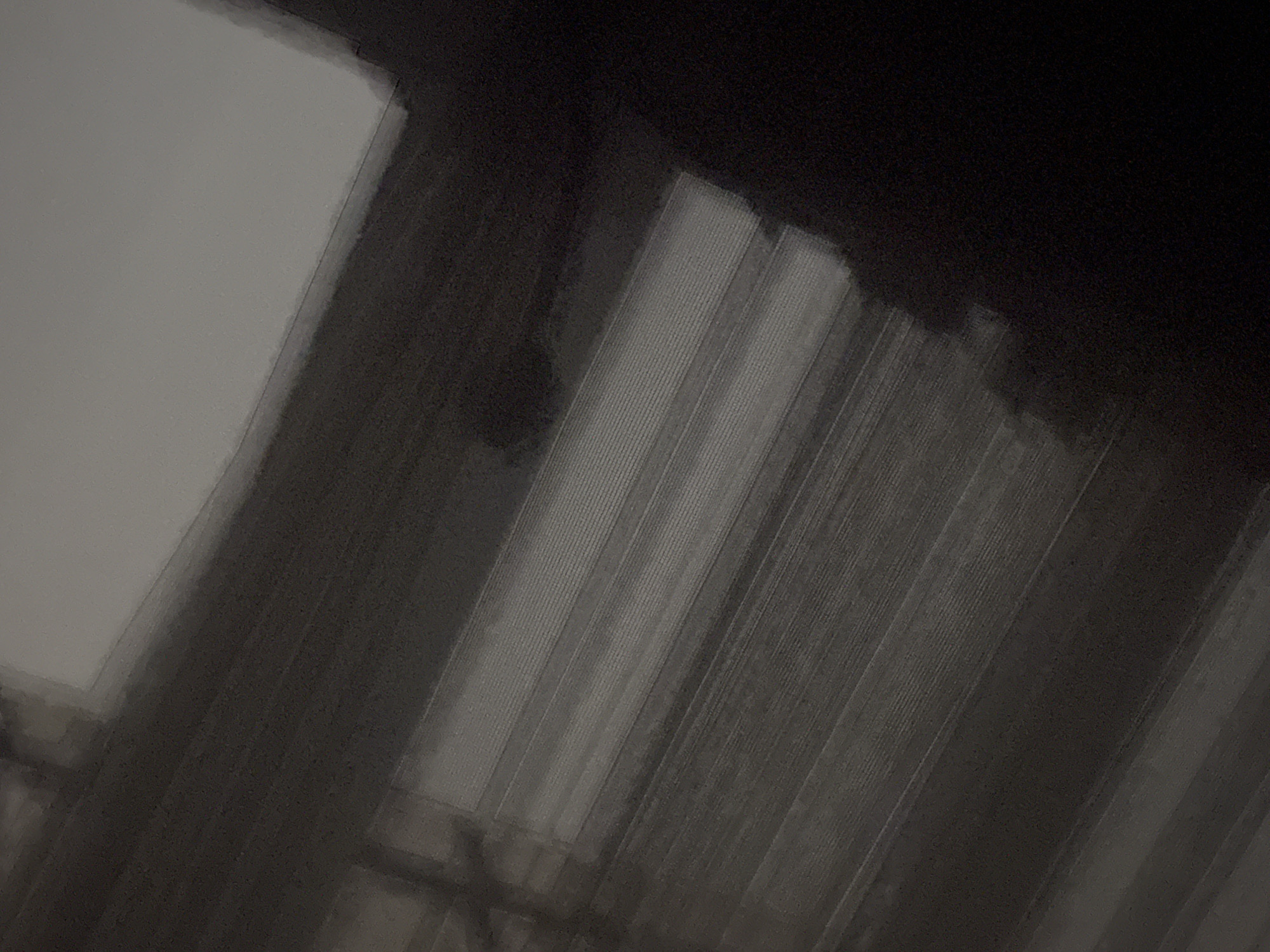Low-angle indoor scene shows vertical patterns in darkened space