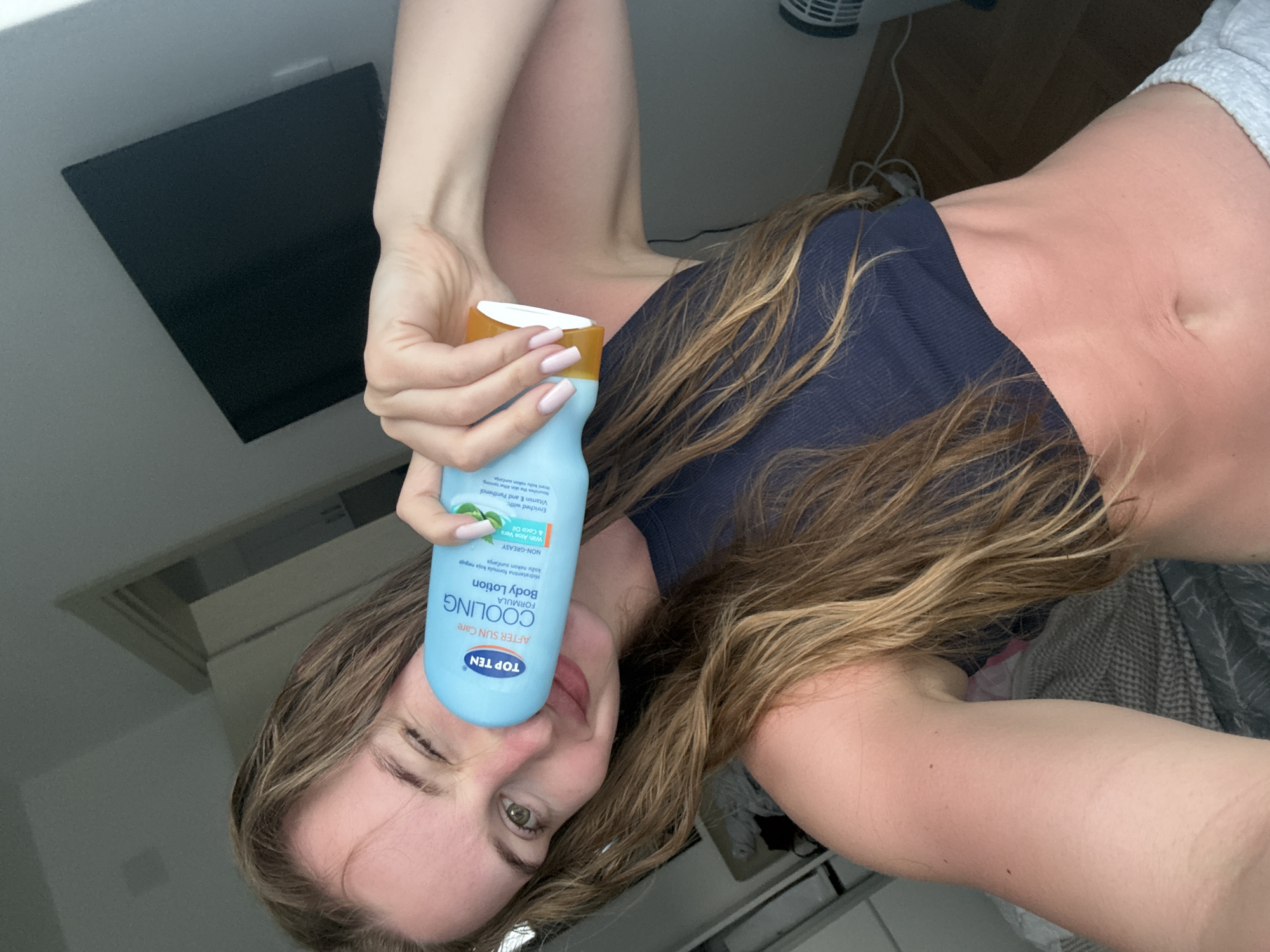 Woman poses with after-sun product in Budva indoor setting
