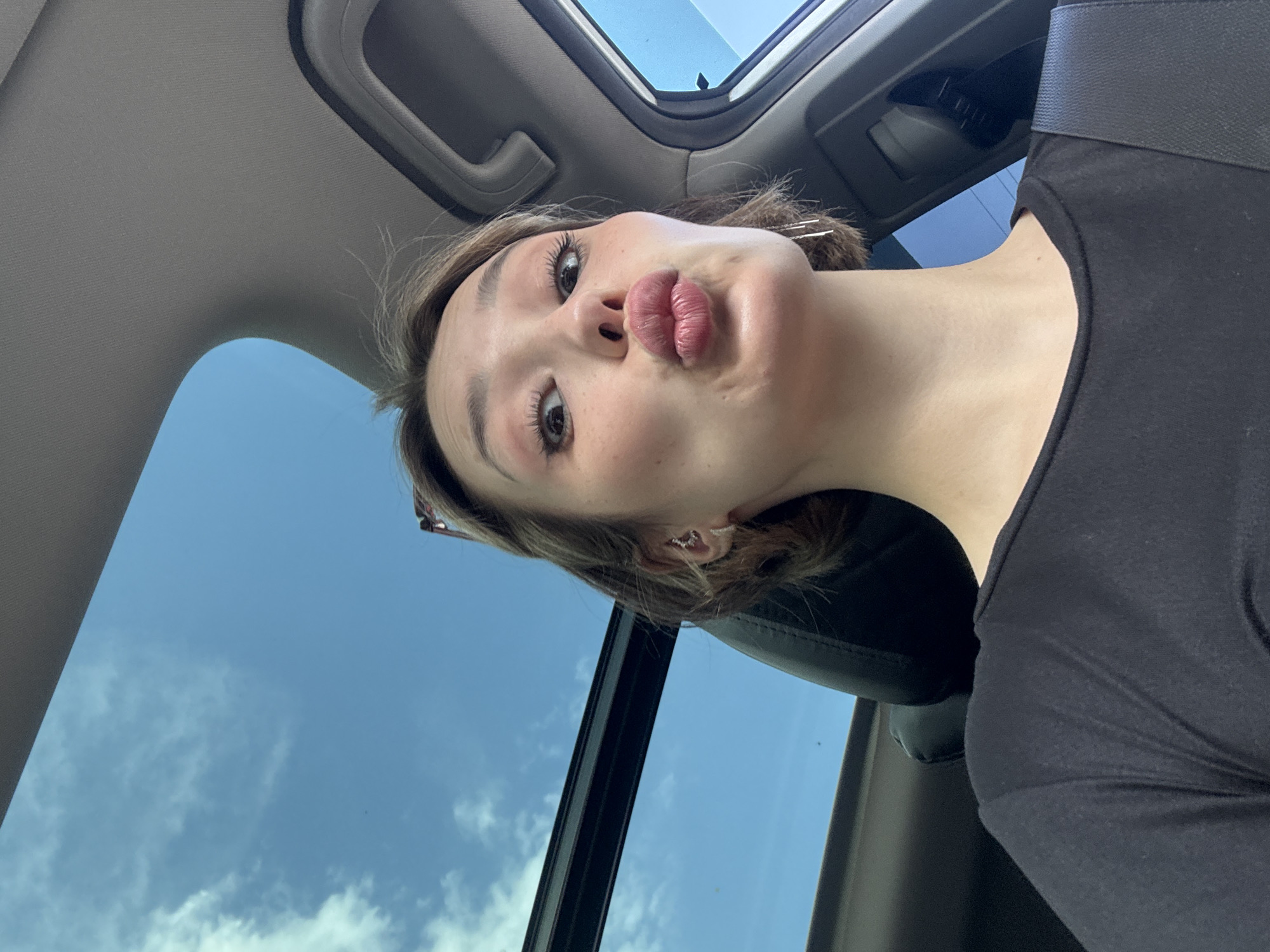 Woman takes selfies in parked car with sunroof