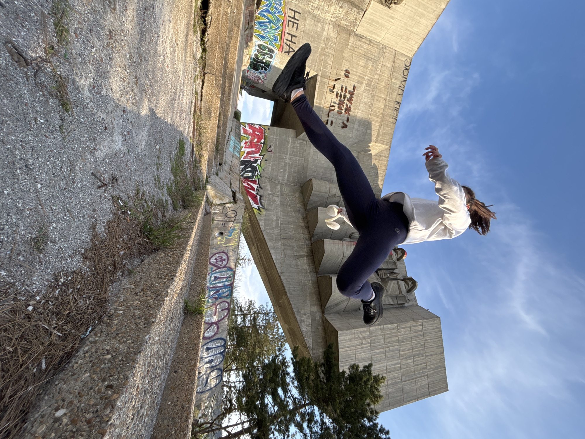 Person exercises near graffitied urban monument