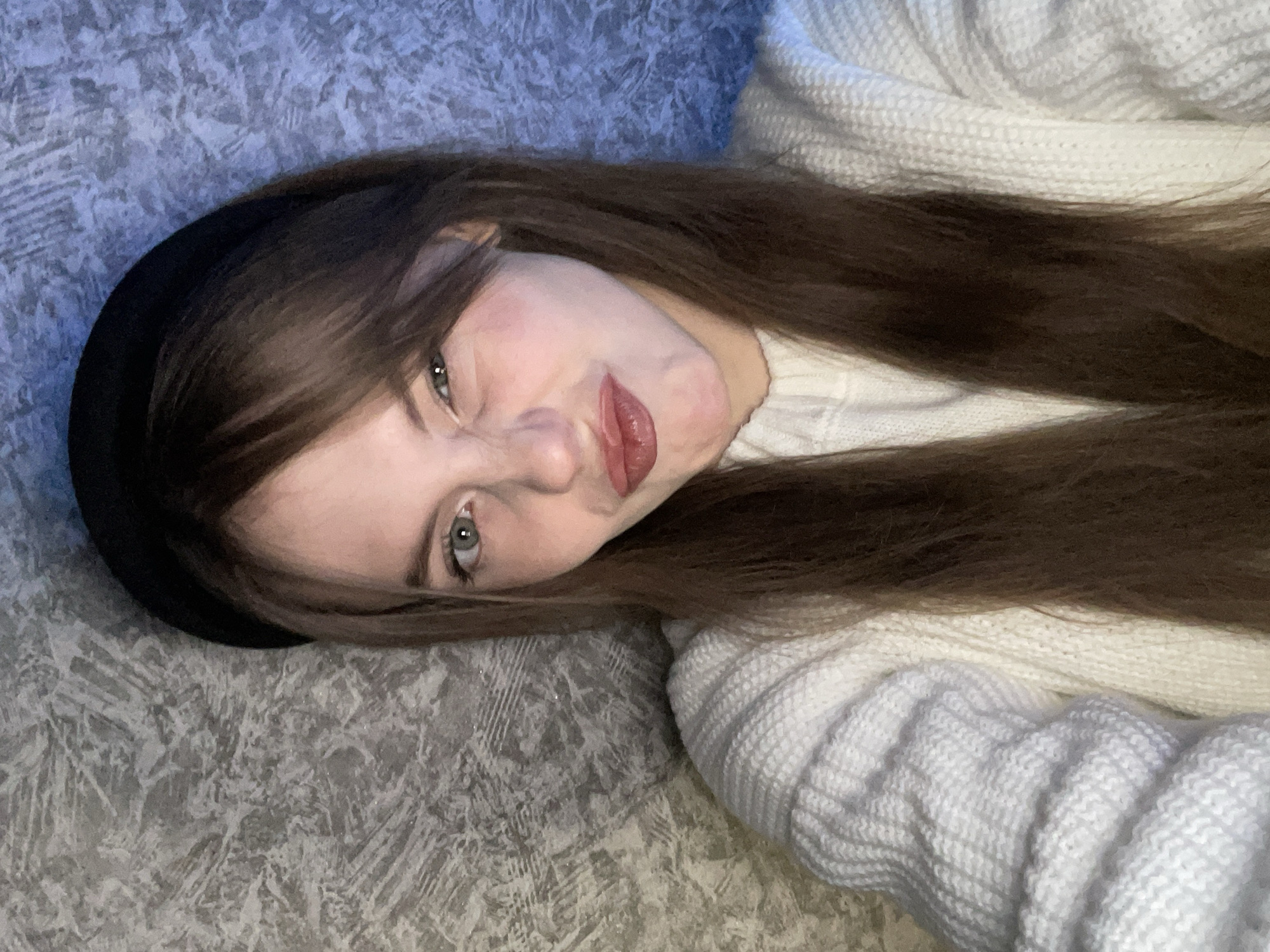 Woman in white sweater rests indoors in Foki, Russia