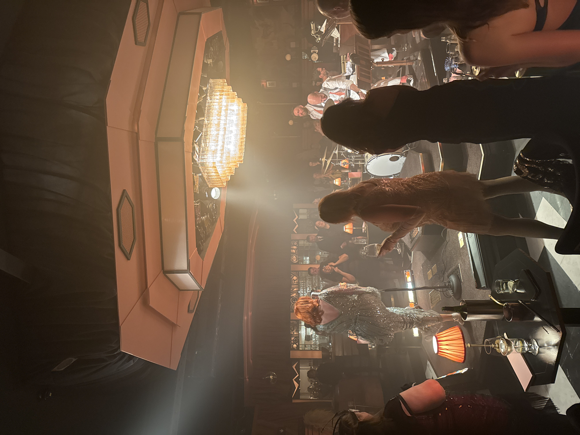Art deco venue with patrons, performers captured in dim lighting