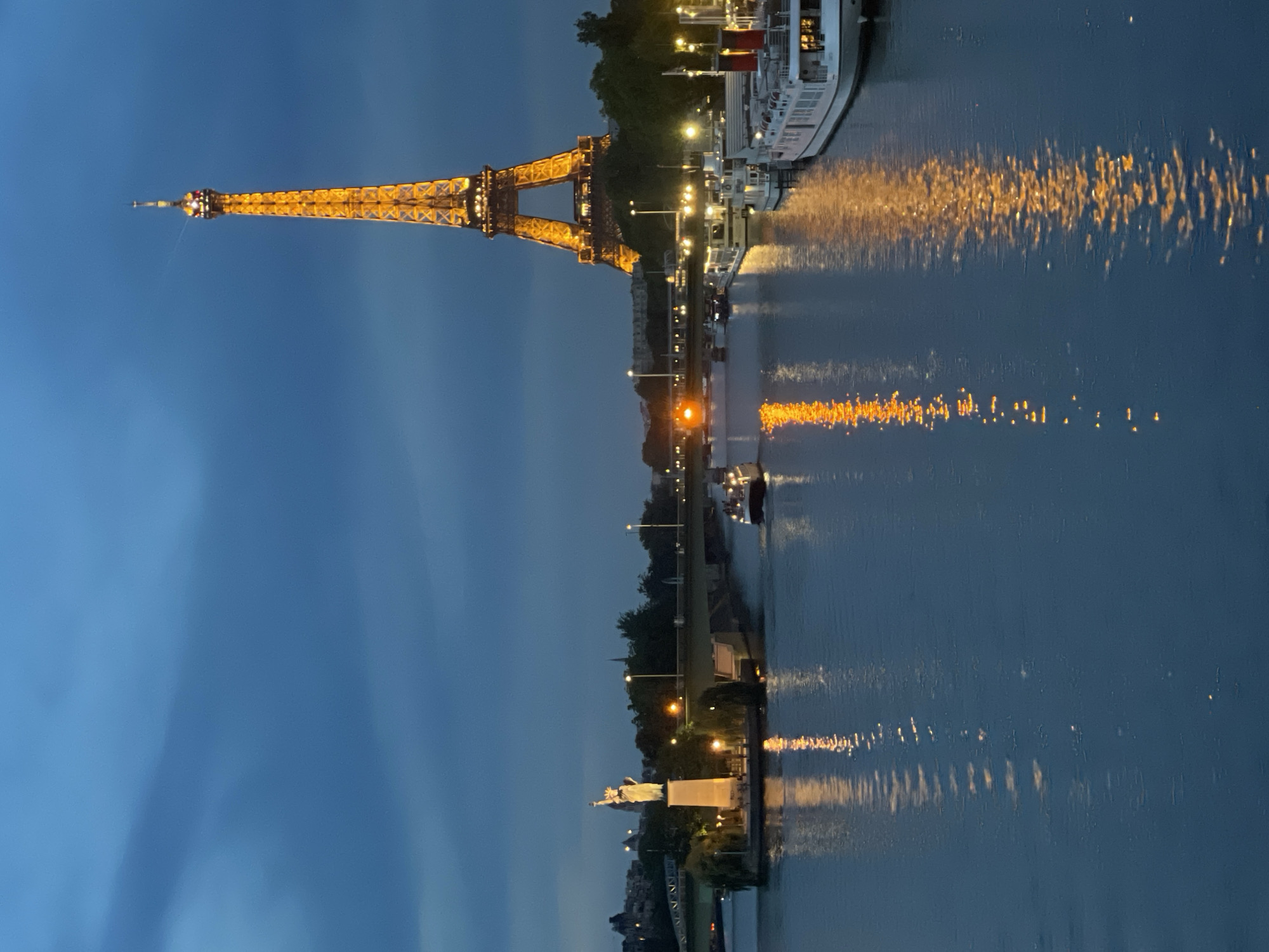 Eiffel Tower glowing gold over the Seine at dusk