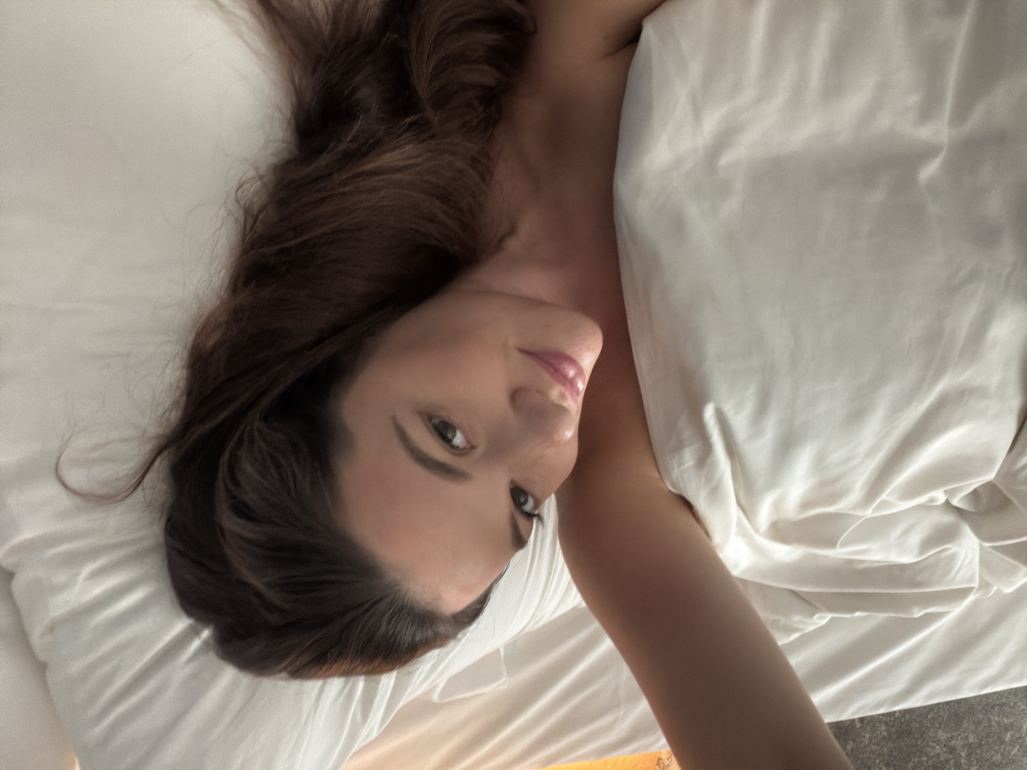 Woman photographed on bed in Athens morning scene