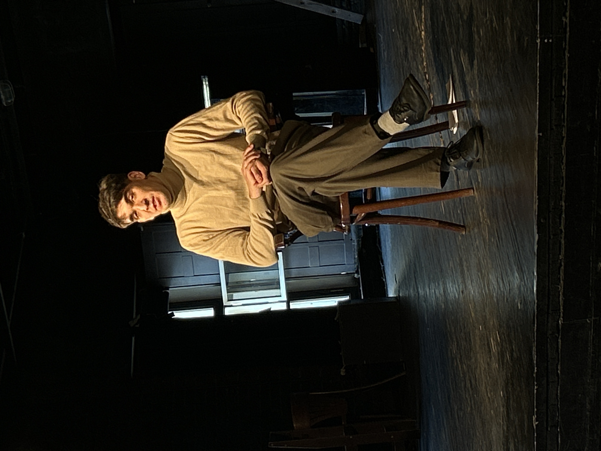 Young man photographed in dimly lit rehearsal space