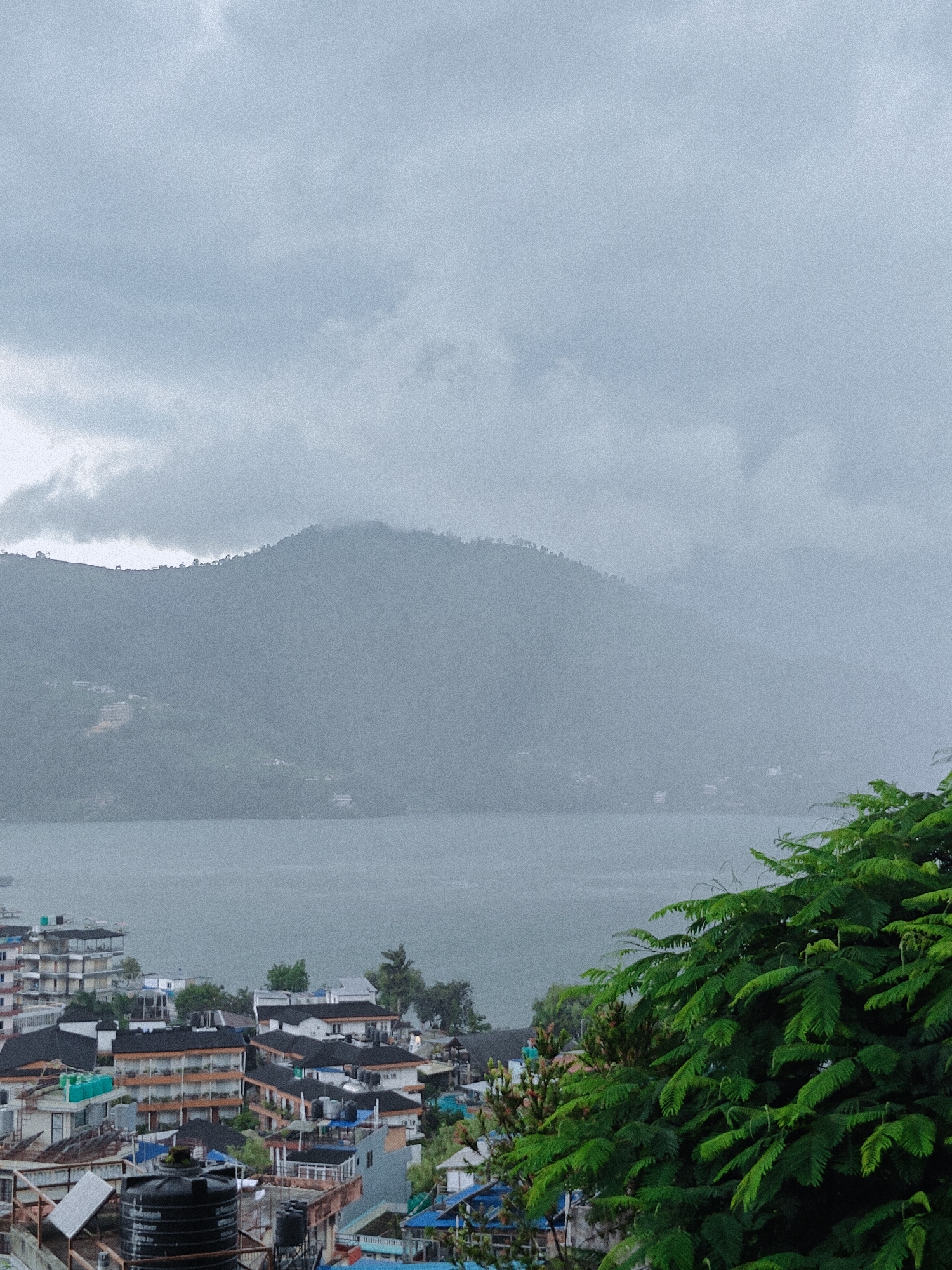 Pokhara under grey skies, lake and city in the rain