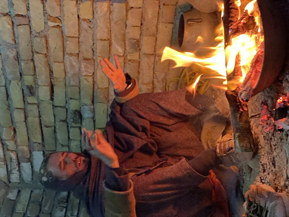 Men gather around campfires for warmth in Kandahar
