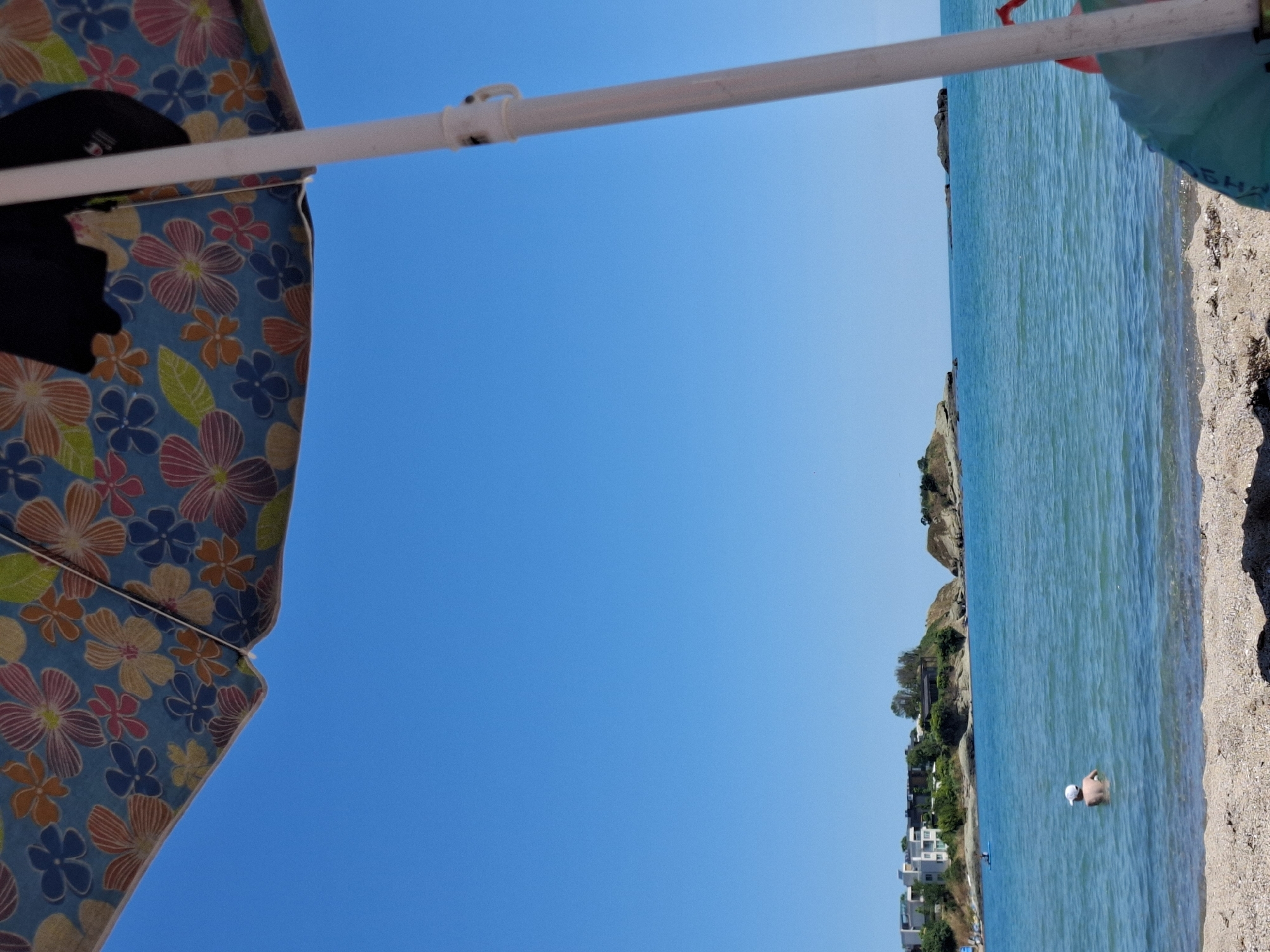 Beach day with swimming and umbrellas under clear skies