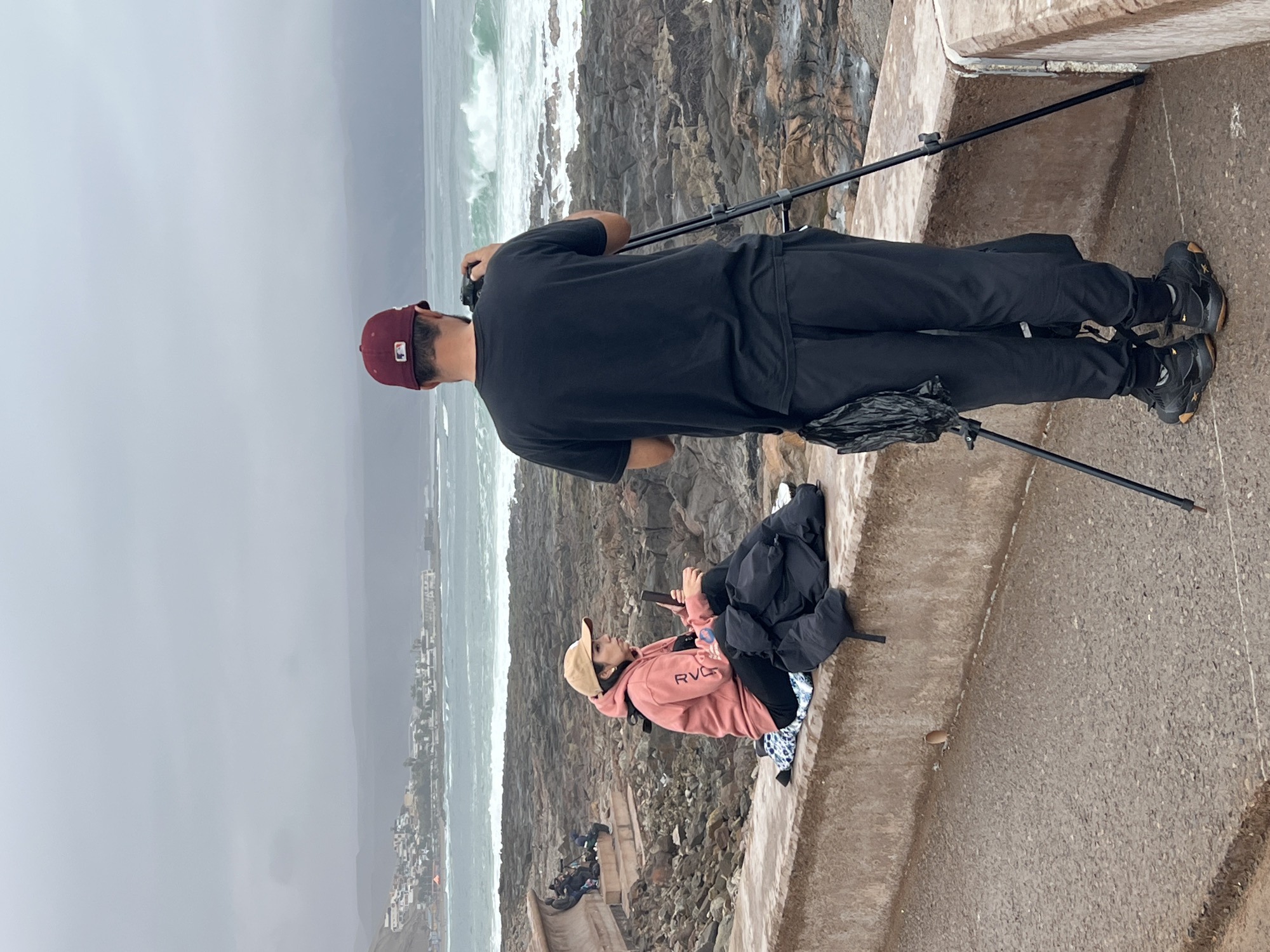 Surfers ride choppy break off Arica's rocky coast