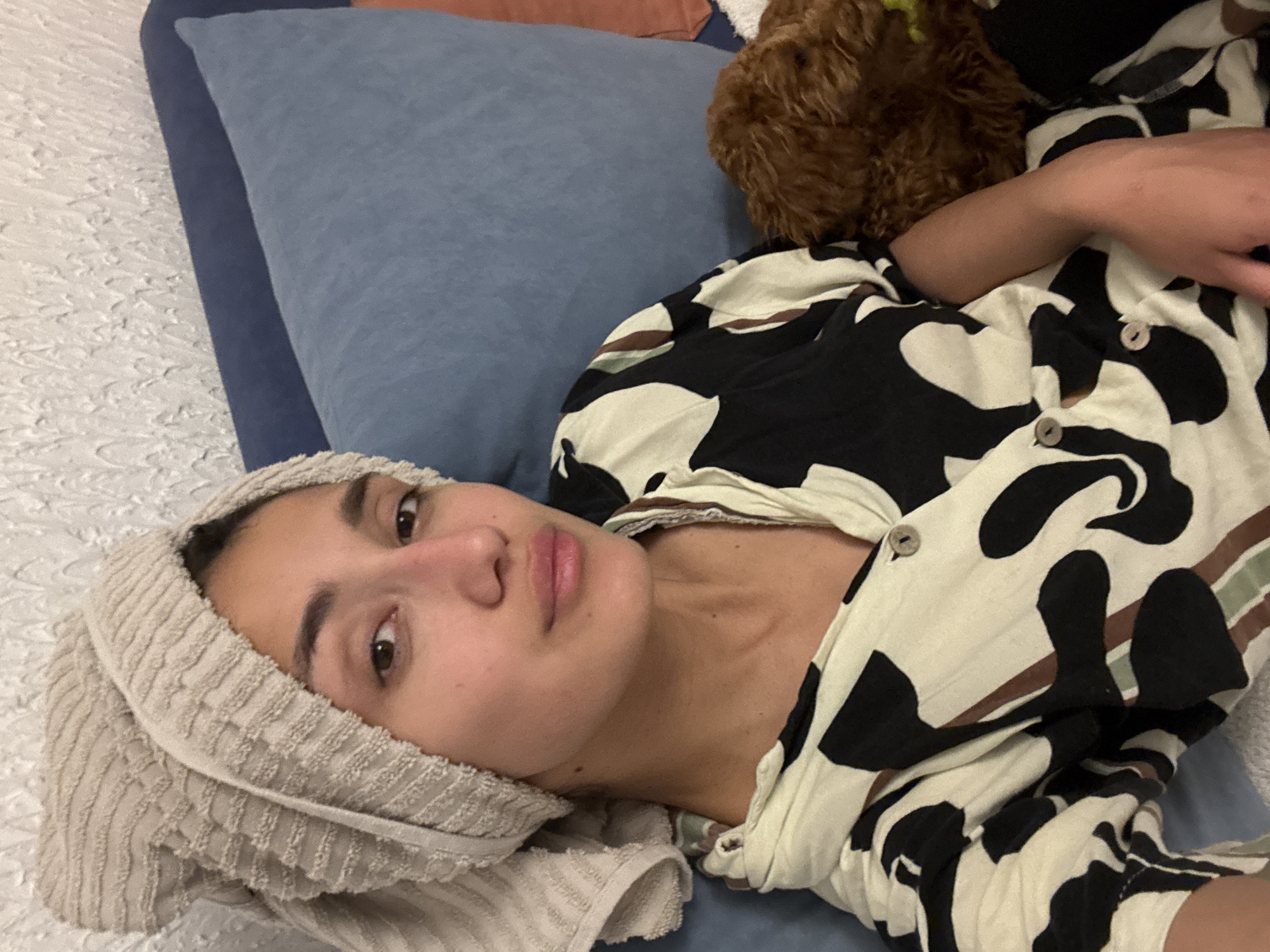 Woman rests with towel-wrapped head in Sutomore bedroom