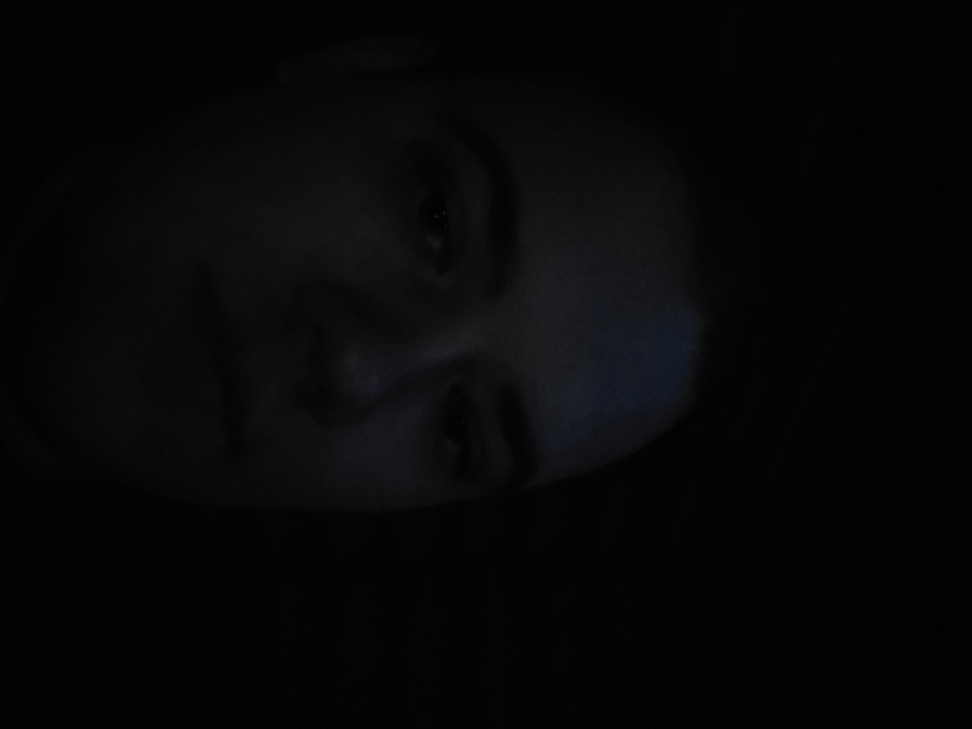 Person in dark room with computer monitor and lighting