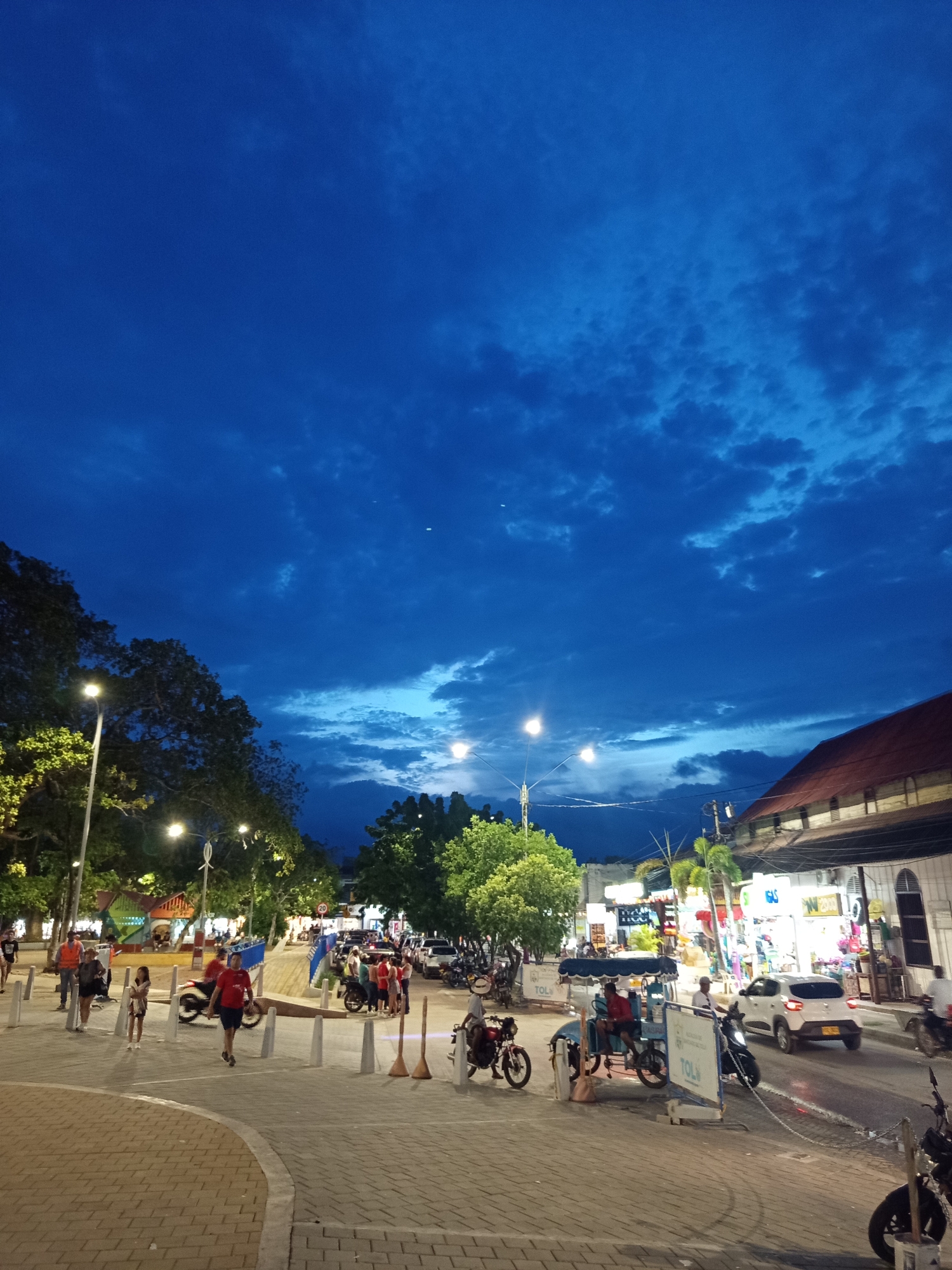 Dusk street life and a scorpion-decaled rickshaw in Tolú