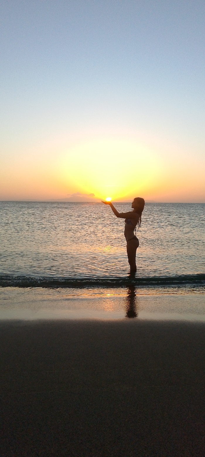 Woman poses with sunset at Juan Griego beach