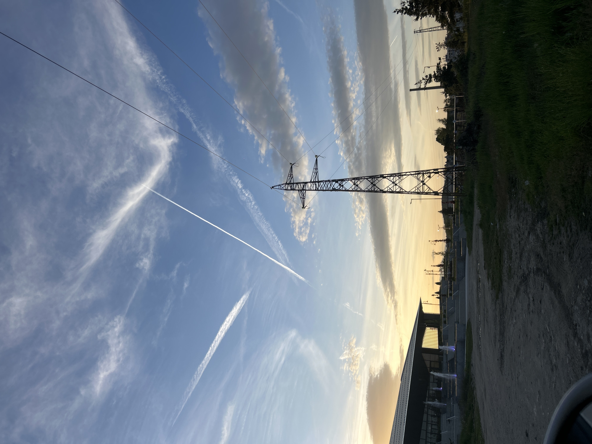 Electrical transmission tower observed under partly cloudy sky