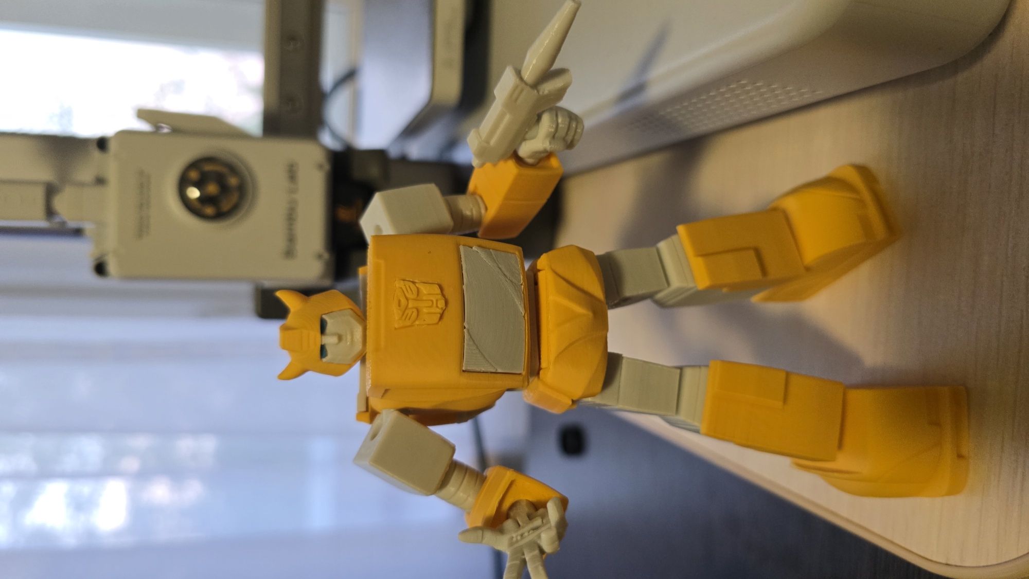 3D printing Transformers figures at home, with a Pomeranian nearby