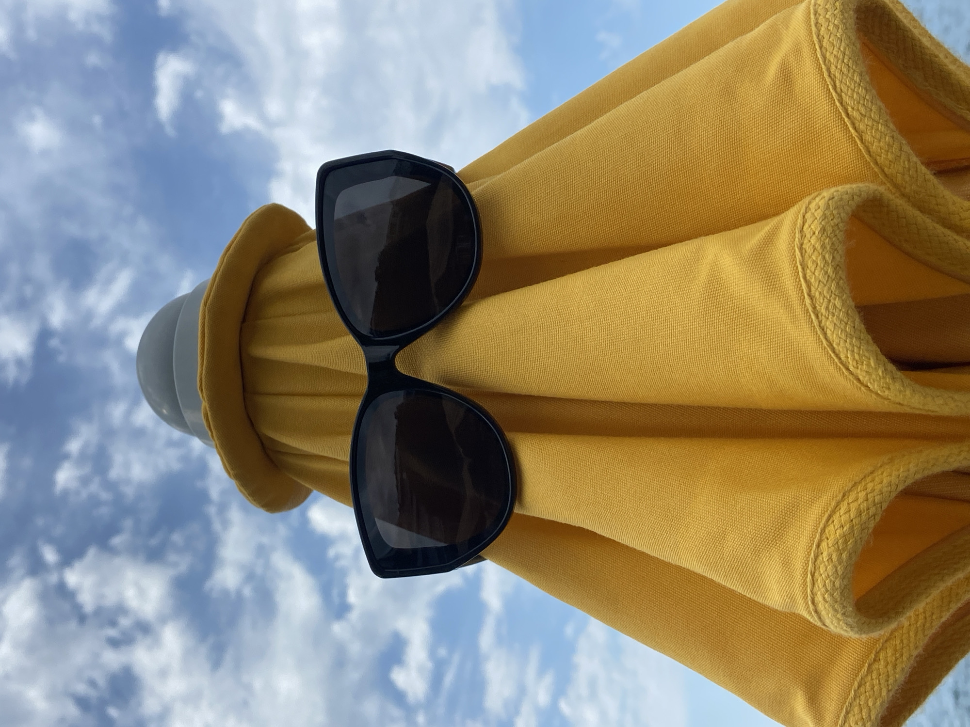 Black sunglasses spotted on yellow umbrella in Montenegro