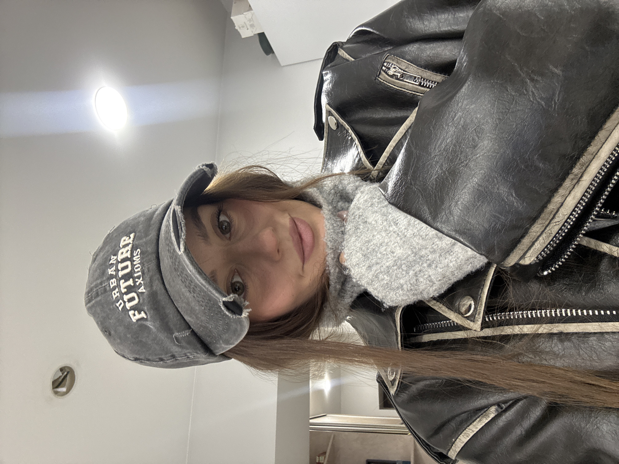 Woman takes selfies in Krasnoyarsk wearing urban-themed cap