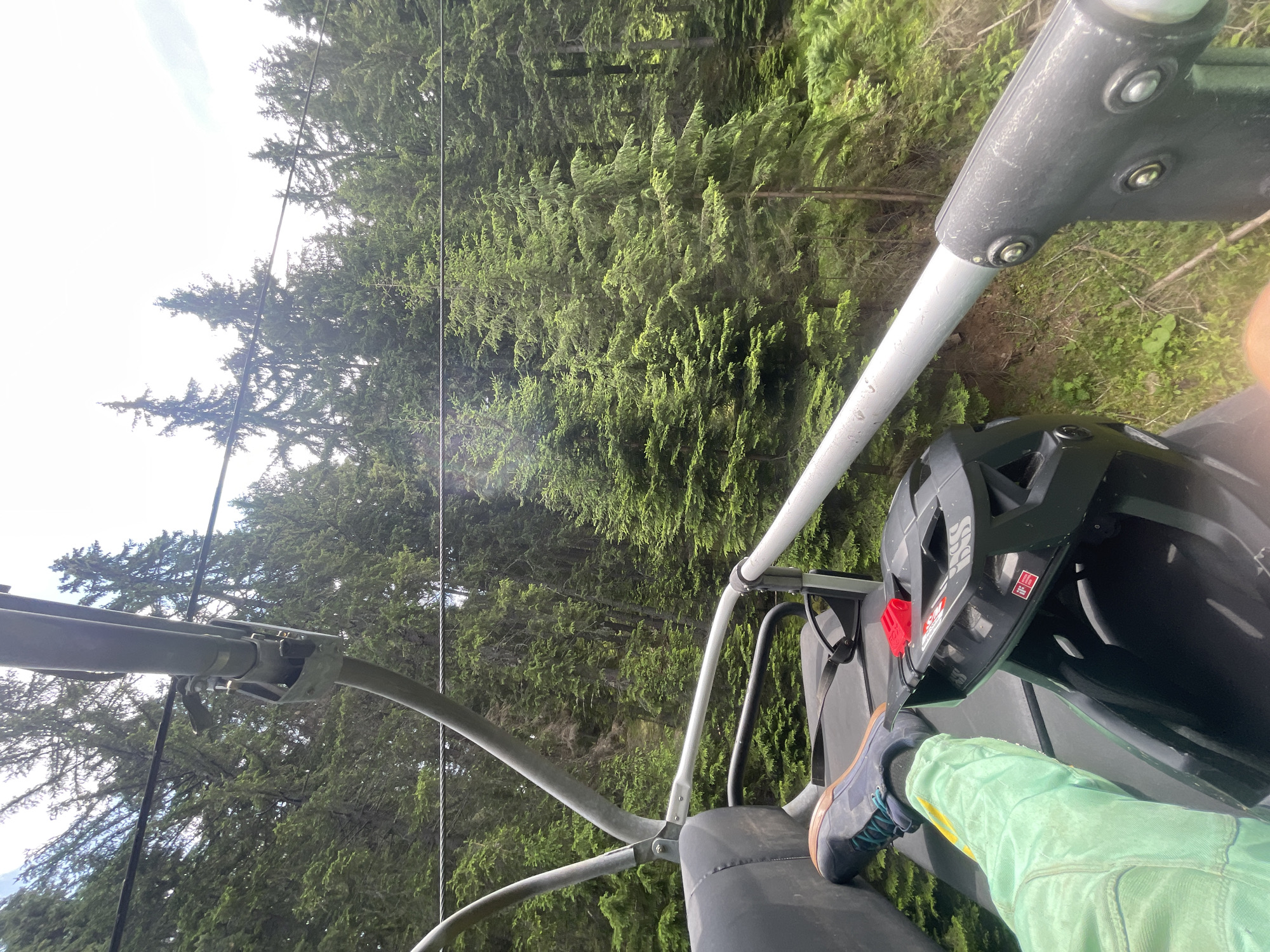 Chairlift ride up Chepelare mountain, bike helmet in tow