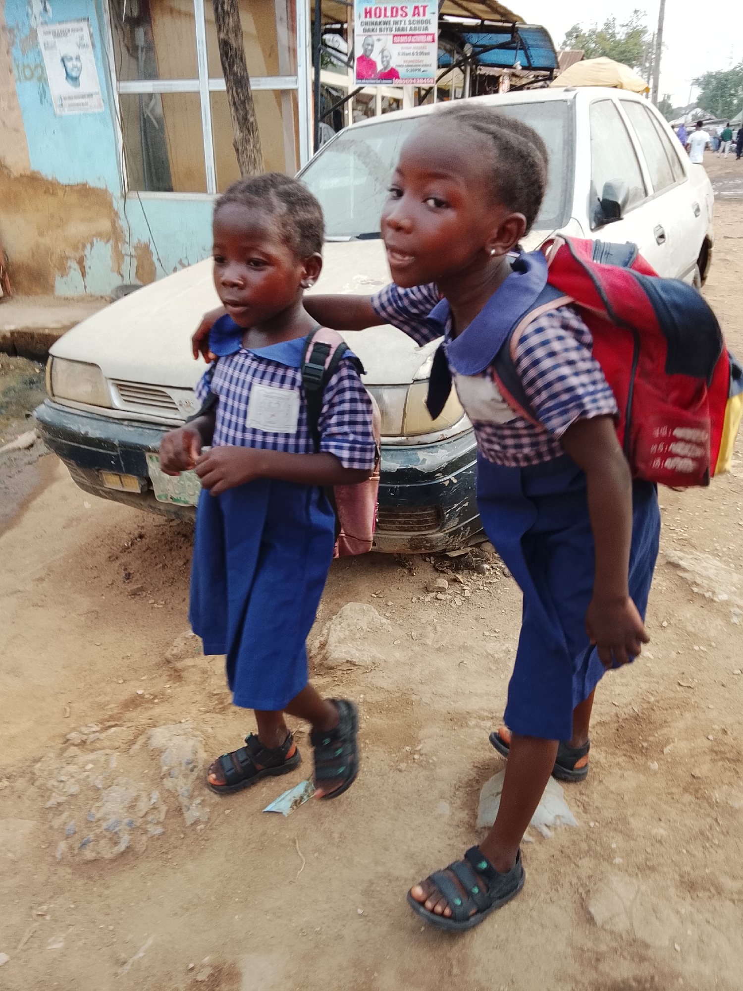 Morning commute on dirt roads in Abuja captures students, motorcyclists