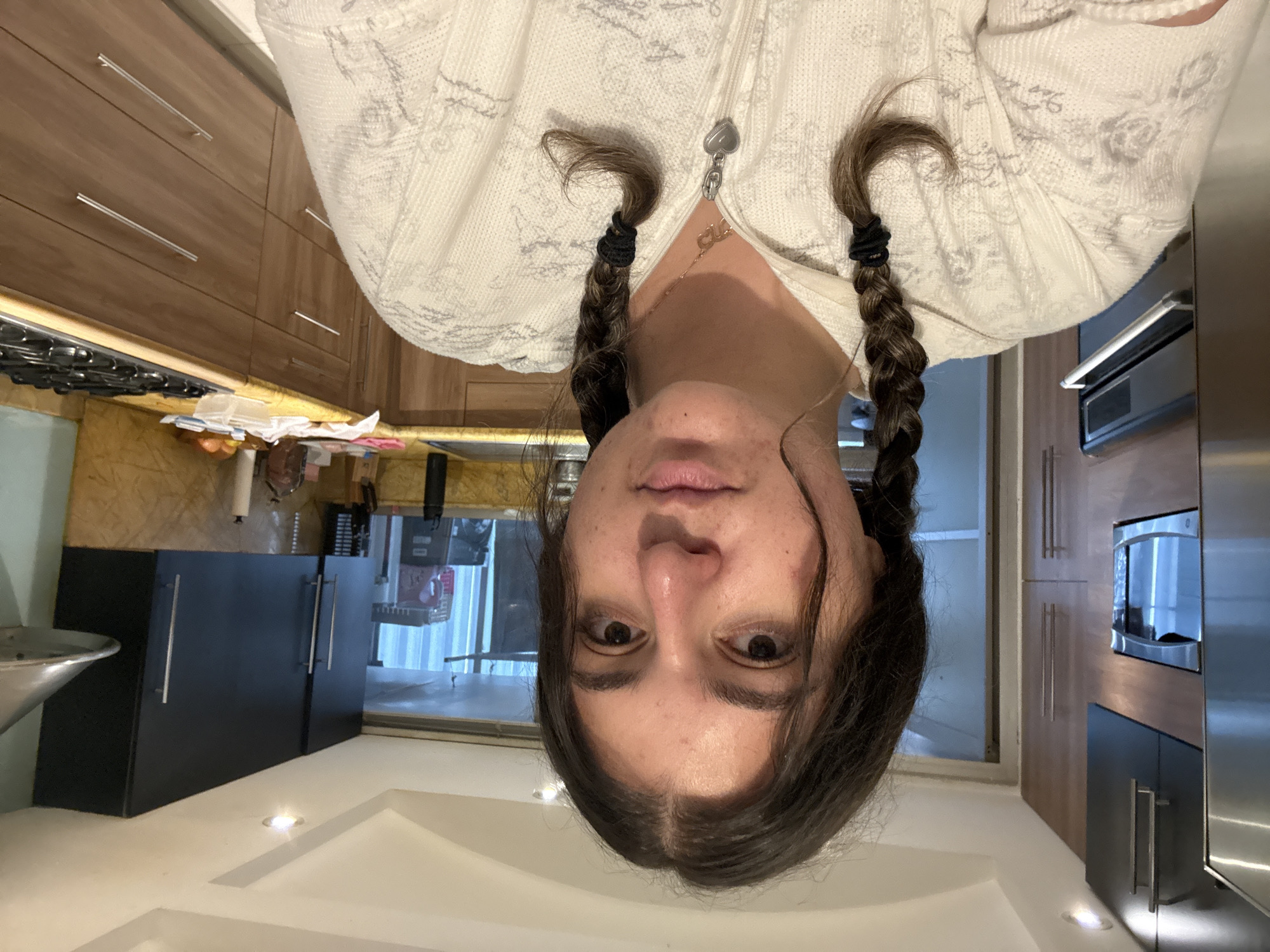 Woman in braided hair captured in kitchen moments, Mexico City