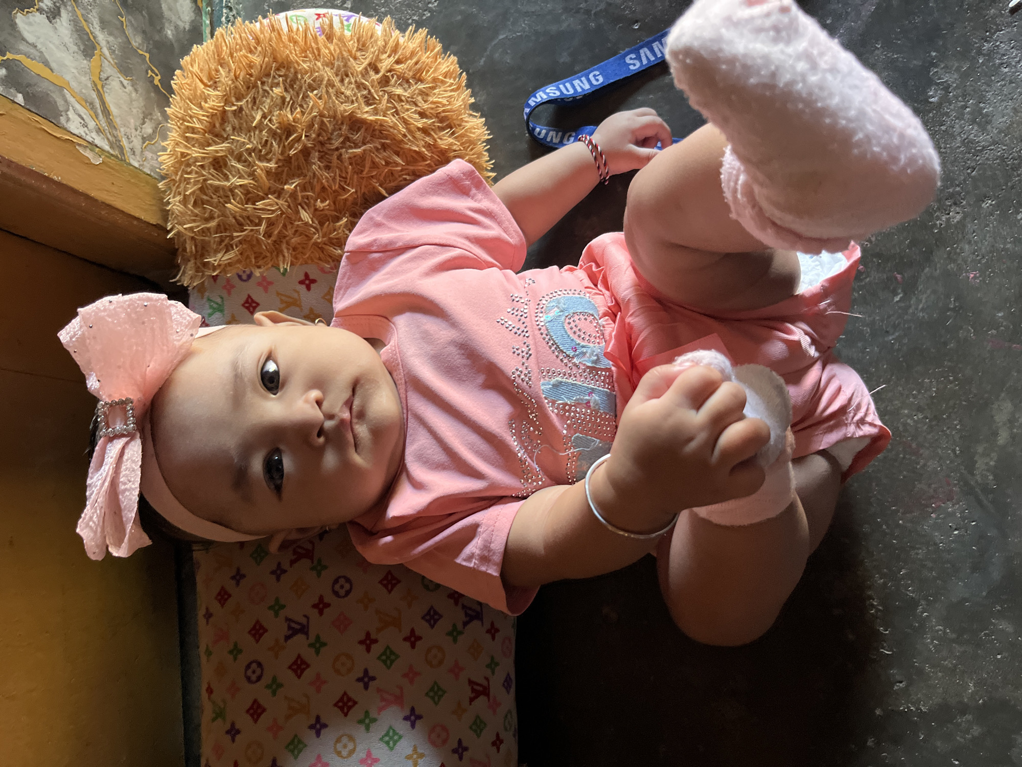 Baby in pink outfit resting at home in Kruengmate