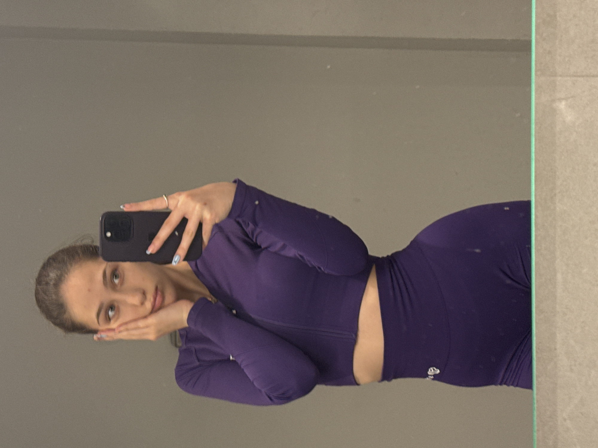 Woman takes mirror selfies in purple workout gear, Sofia