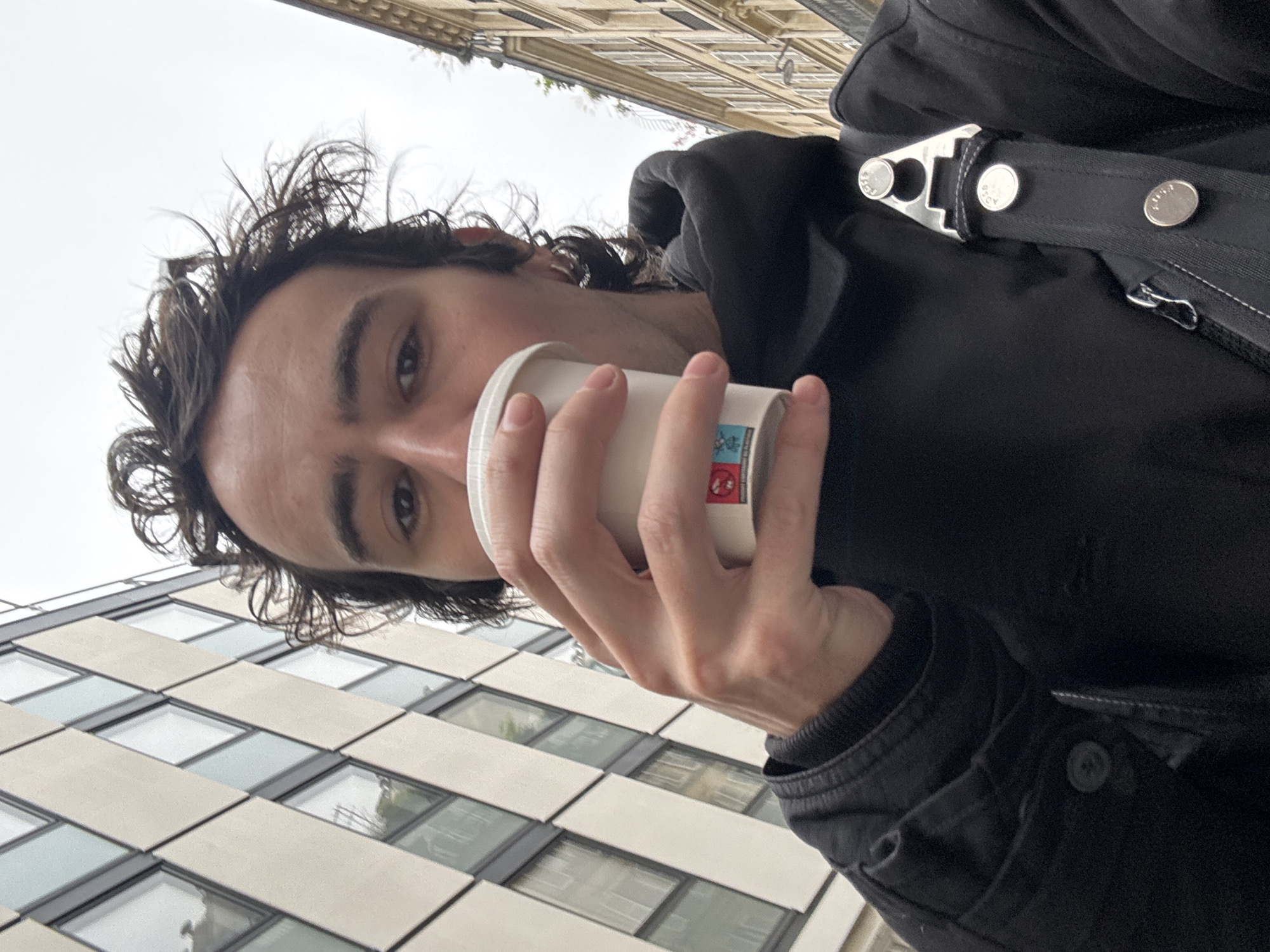 Man drinks from cup on Paris street morning