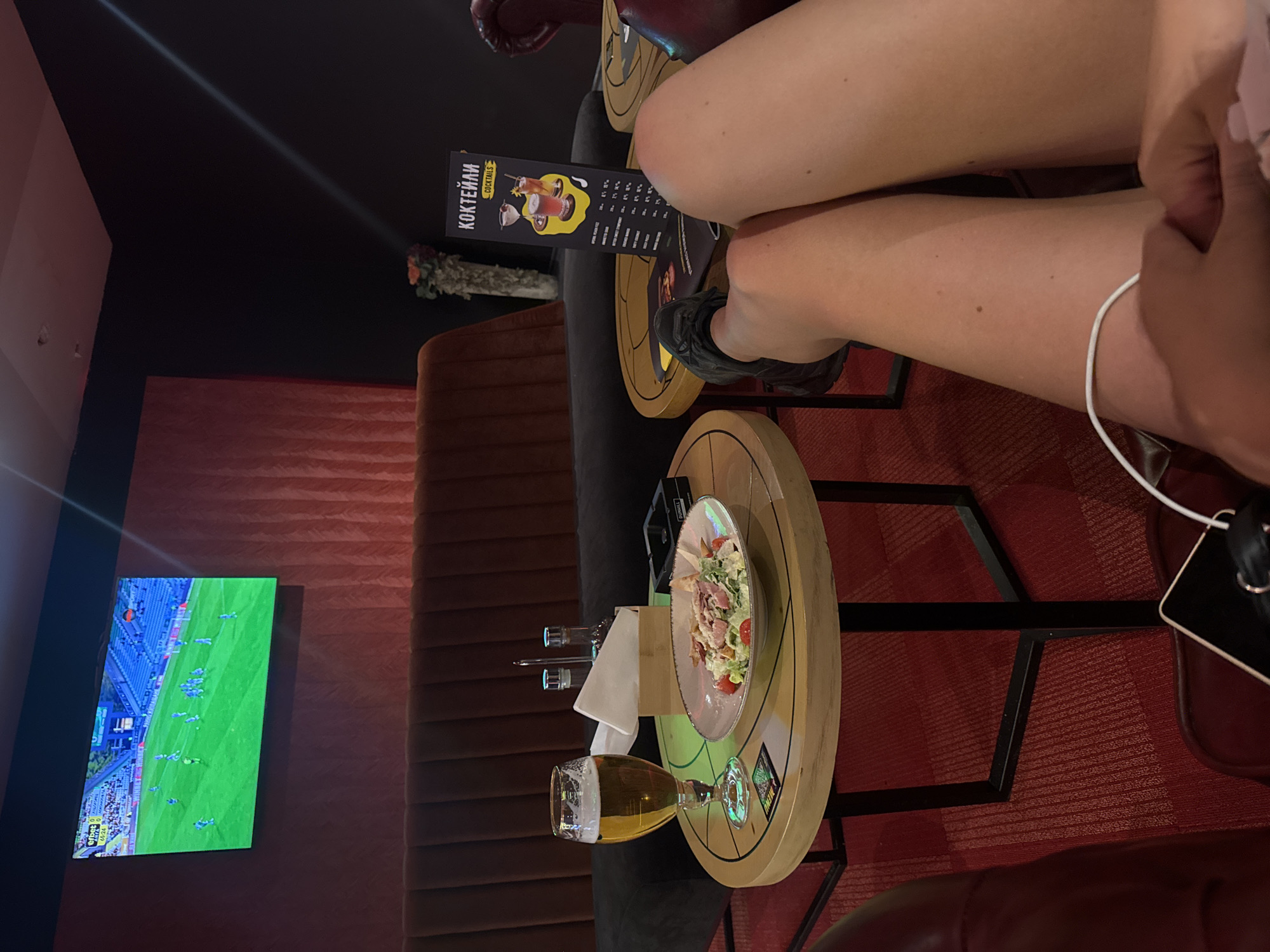 Person enjoys beer and meal while watching football in Sofia bar