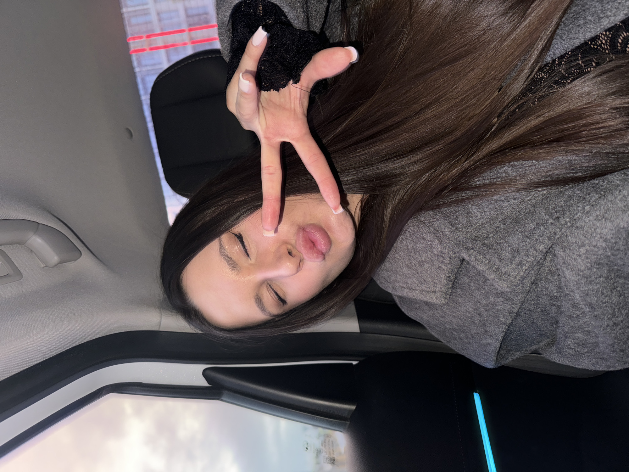 Woman in car makes peace sign in Moscow