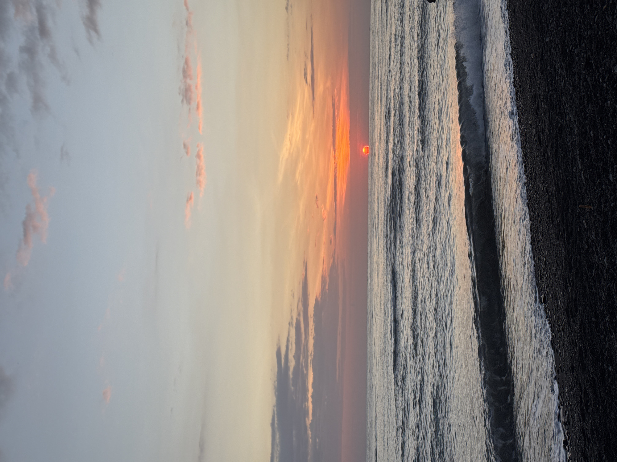 Black pebble beach sunset at a resort in Abang, Bali